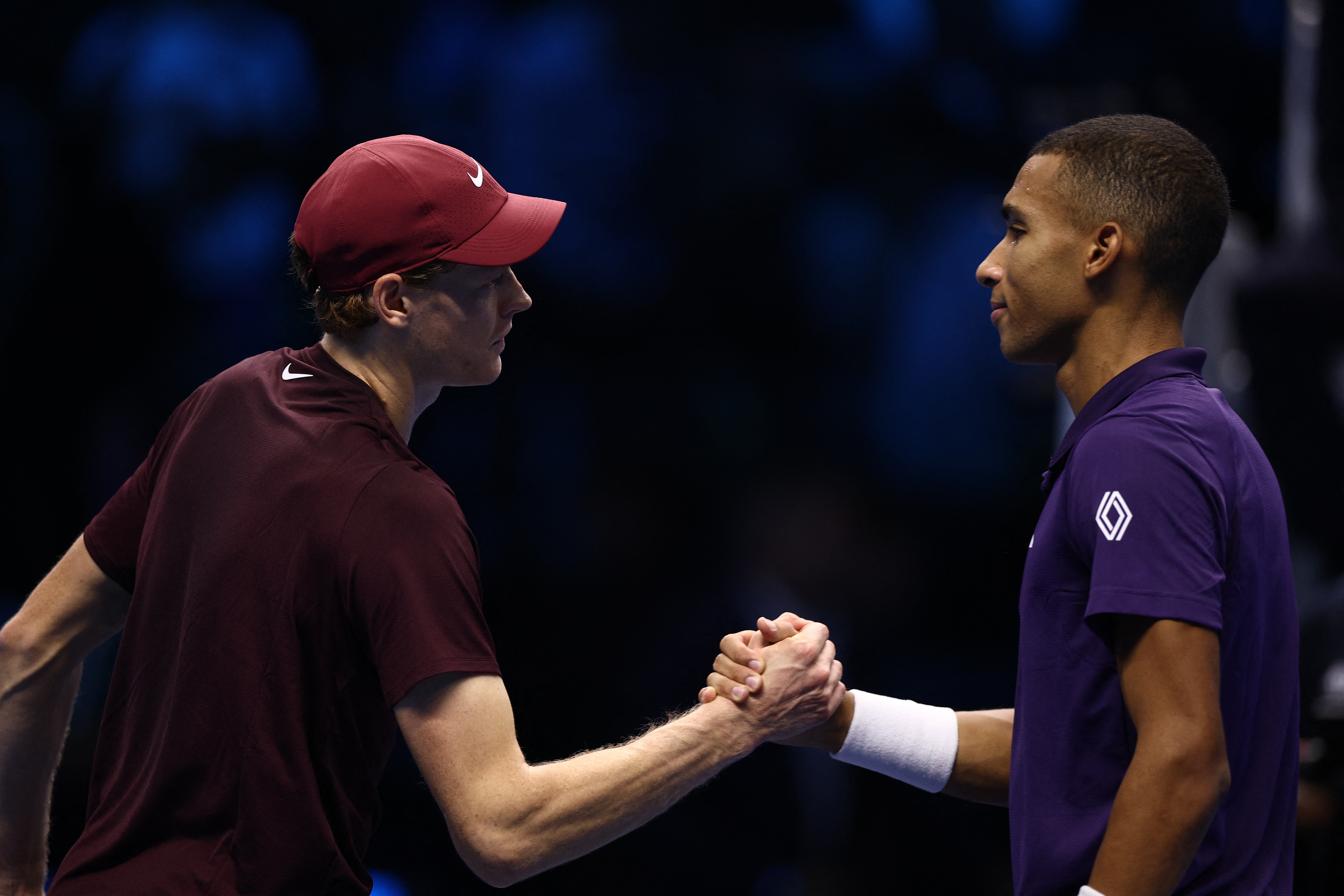 Sinner shakes hands with Auger-Aliassime, right, after winning his group stage match