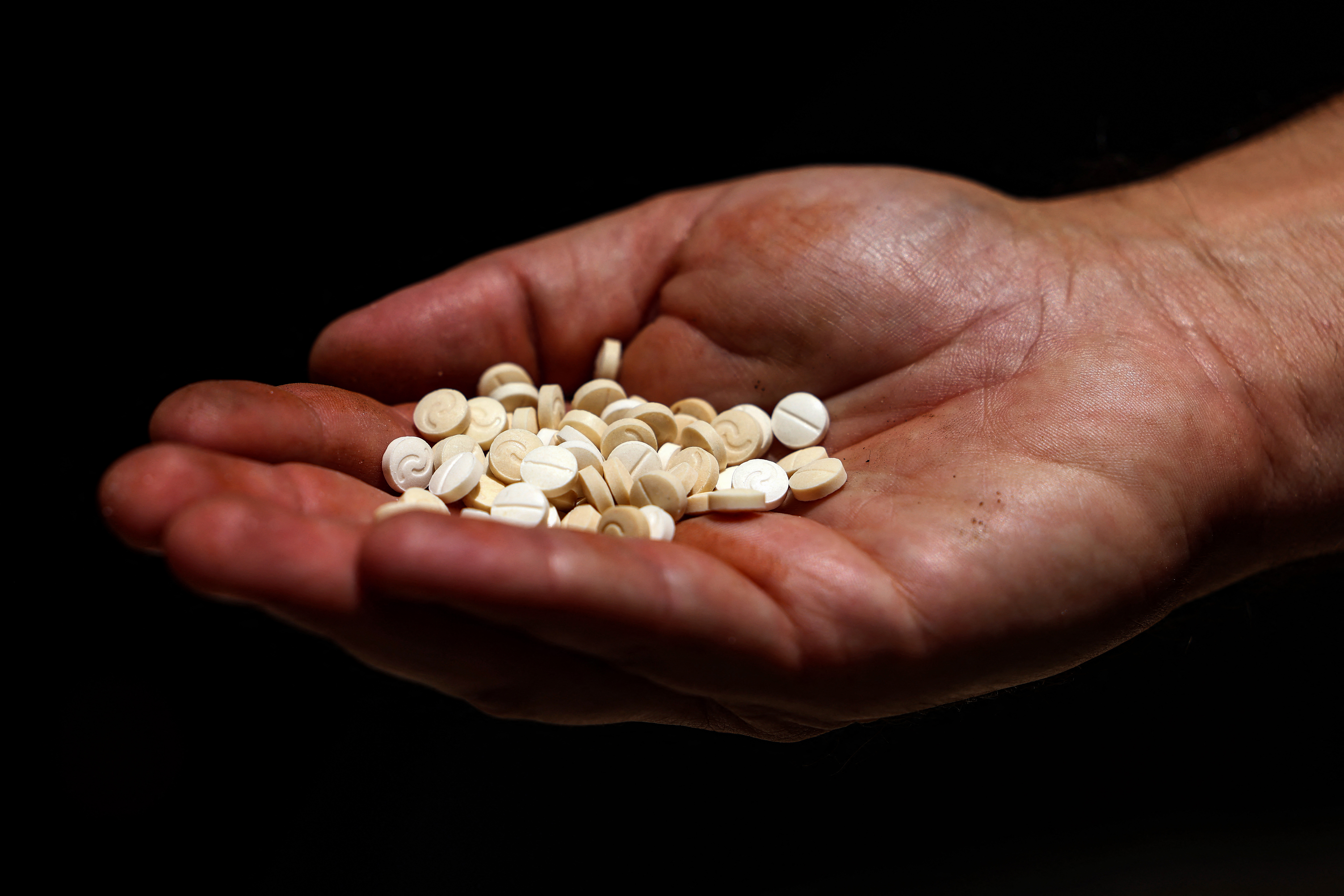 A Lebanese security official holds a handful of confiscated captagon pills in his palm at the judicial police headquarters in the city of Zahle in Lebanon's central Bekaa valley on July 21, 2022. A decade of appalling civil war has left Syria fragmented and in ruins but one thing crosses every frontline: the drug fenethylline, commercially known as captagon. The stimulant -- once notorious for its association with Islamic State fighters -- has spawned an illegal $10-billion industry that not only props up the pariah regime of President Bashar al-Assad, but many of his enemies. It has turned Syria into the world's latest narco state, and sunk deep roots in neighbouring Lebanon as its economy has collapsed. (Photo by JOSEPH EID / AFP)