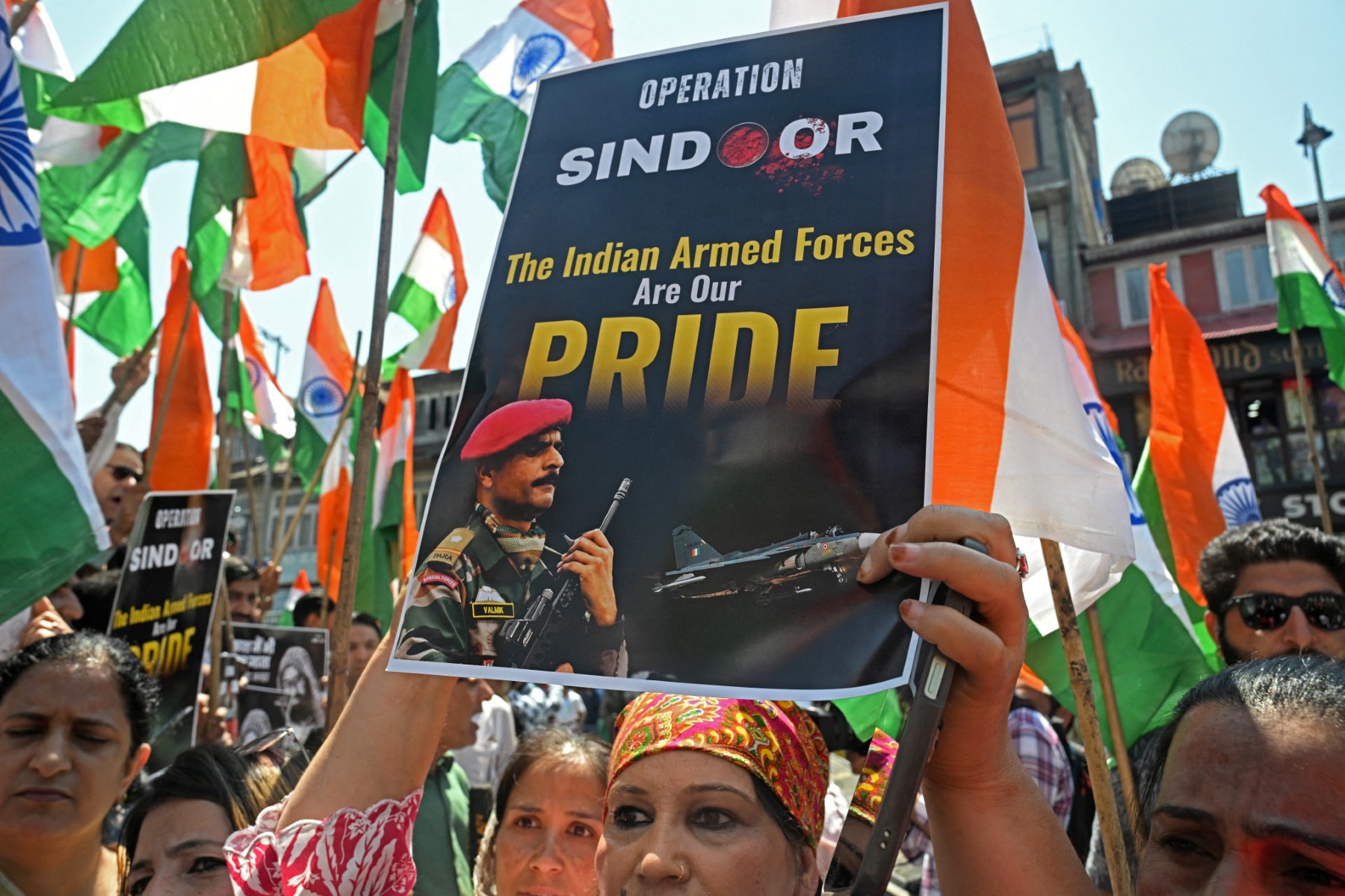 A supporter of India’s Bharatiya Janata Party (BJP) holds a placard during a rally expressing solidarity with the Indian armed forces, in Srinagar, on May 15, 2025, following a ceasefire between Pakistan and India
