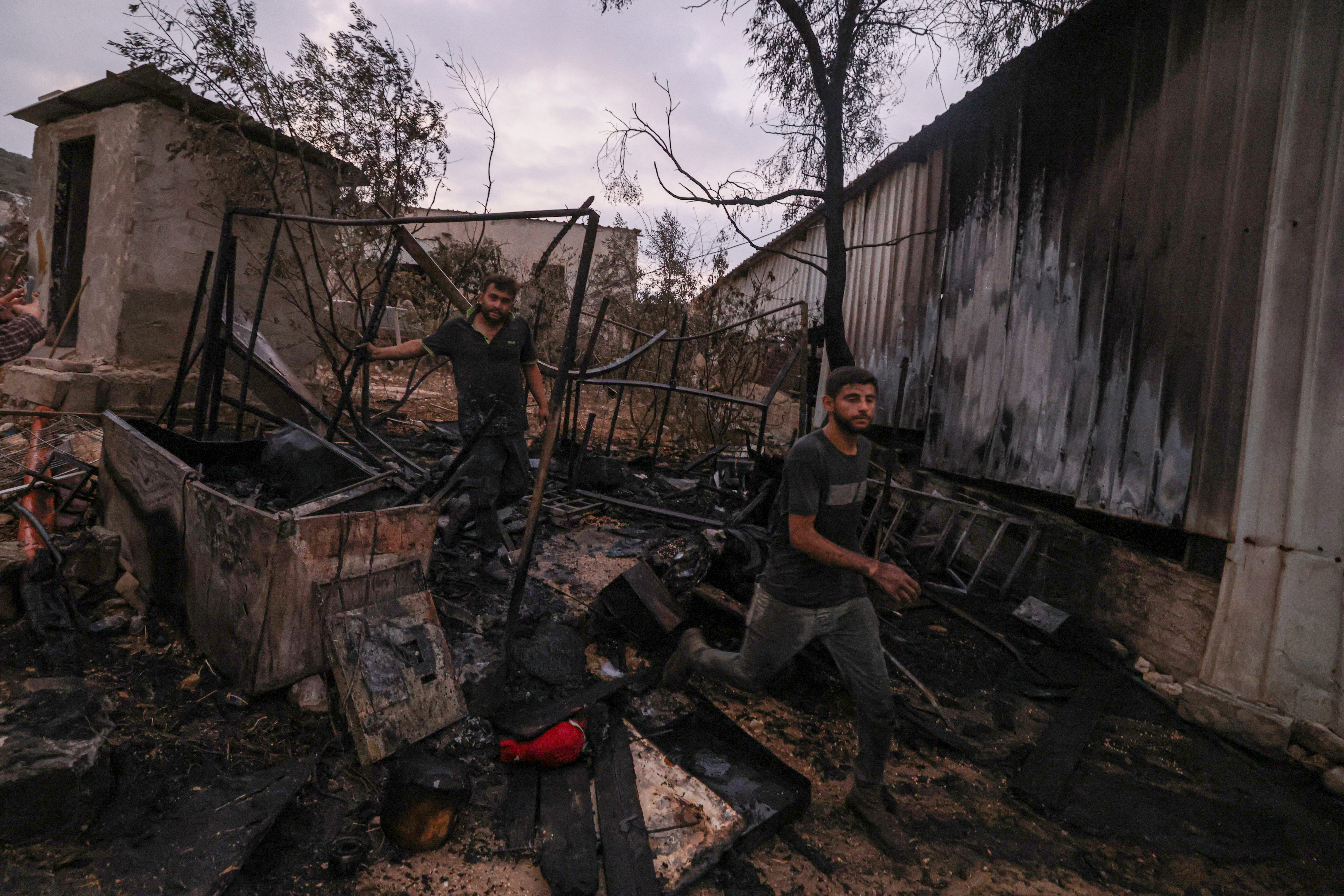 Palestinians inspect parts of a burnt house after an Israeli settlers attack in the village of Beit Lid [Jaafar Ashtiyeh/AFP]