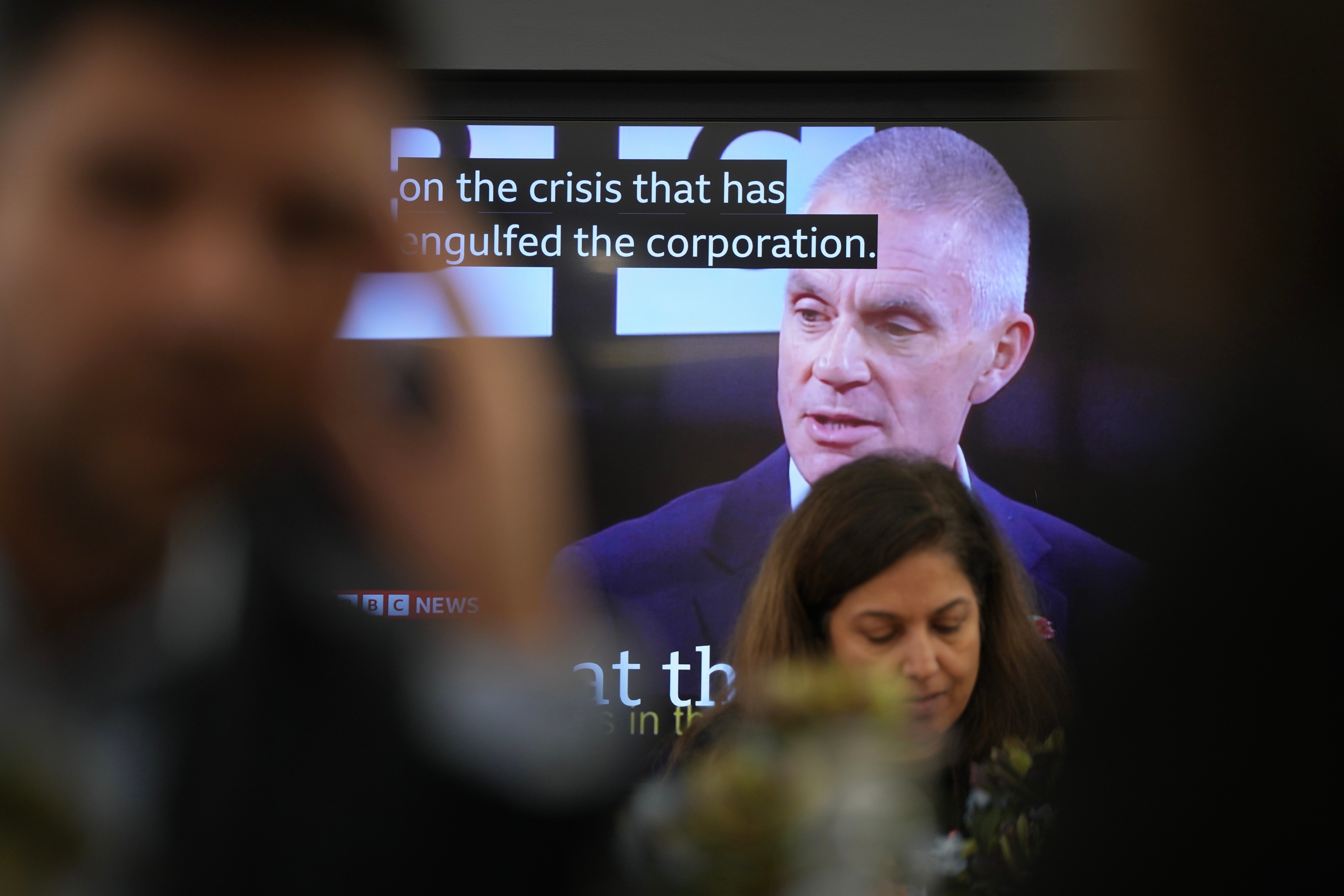 A TV screen shows a news broadcast