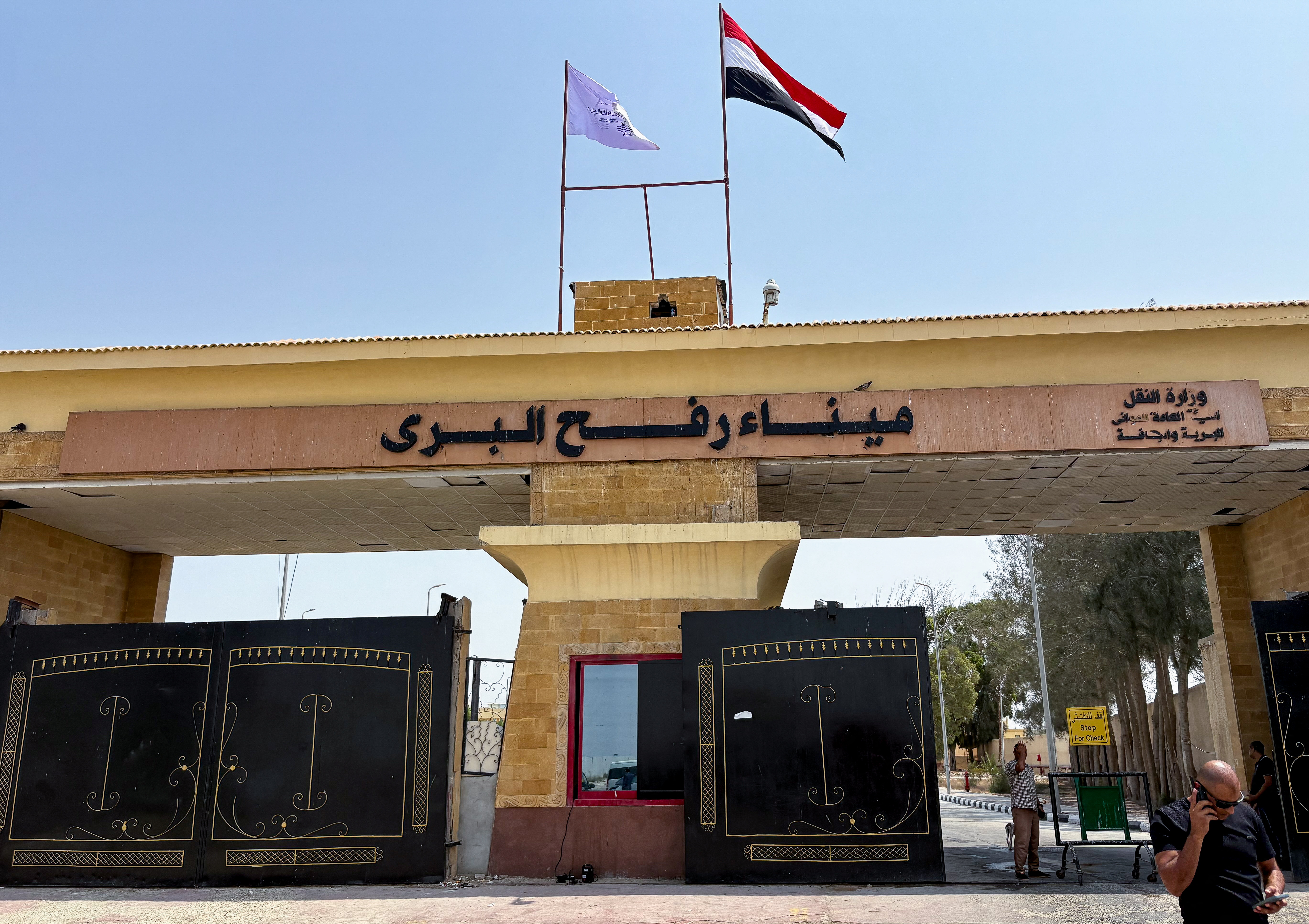People stand at the Rafah border crossing between Egypt and the Gaza Strip.