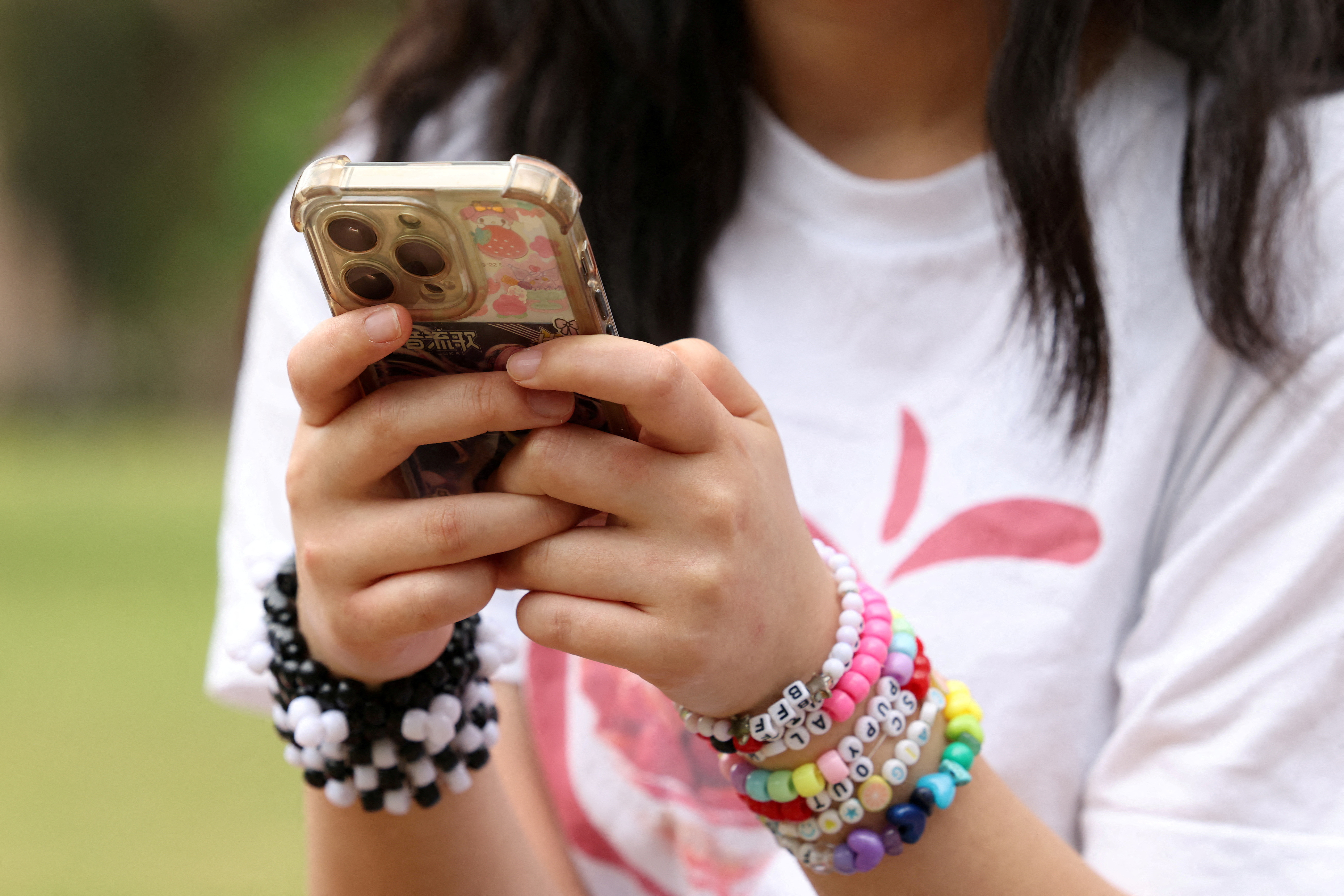 A girl in Sydney holds her phone in the run-up to Australia’s nationwide social media ban for children aged below 16