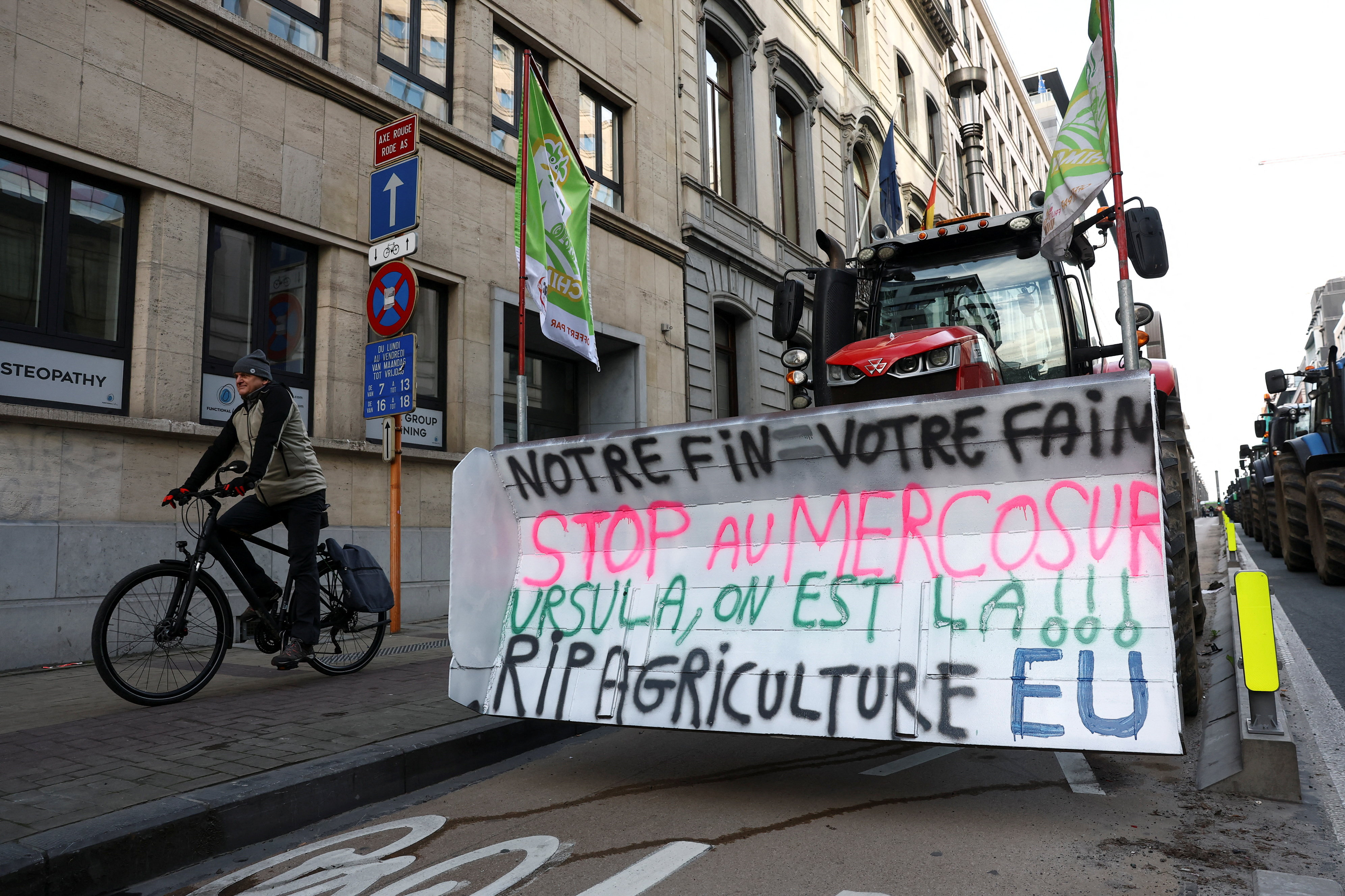 A tractor with a text reading: "Our end = Your hunger, Stop Mercosur, Ursula, we're here, RIP EU agriculture" is parked on a street, as farmers protest against the EU-Mercosur free-trade deal between the European Union and the South American countries of Mercosur, on the day of a European Union leaders' summit, in Brussels, Belgium, December 18, 2025. REUTERS/Yves Herman
