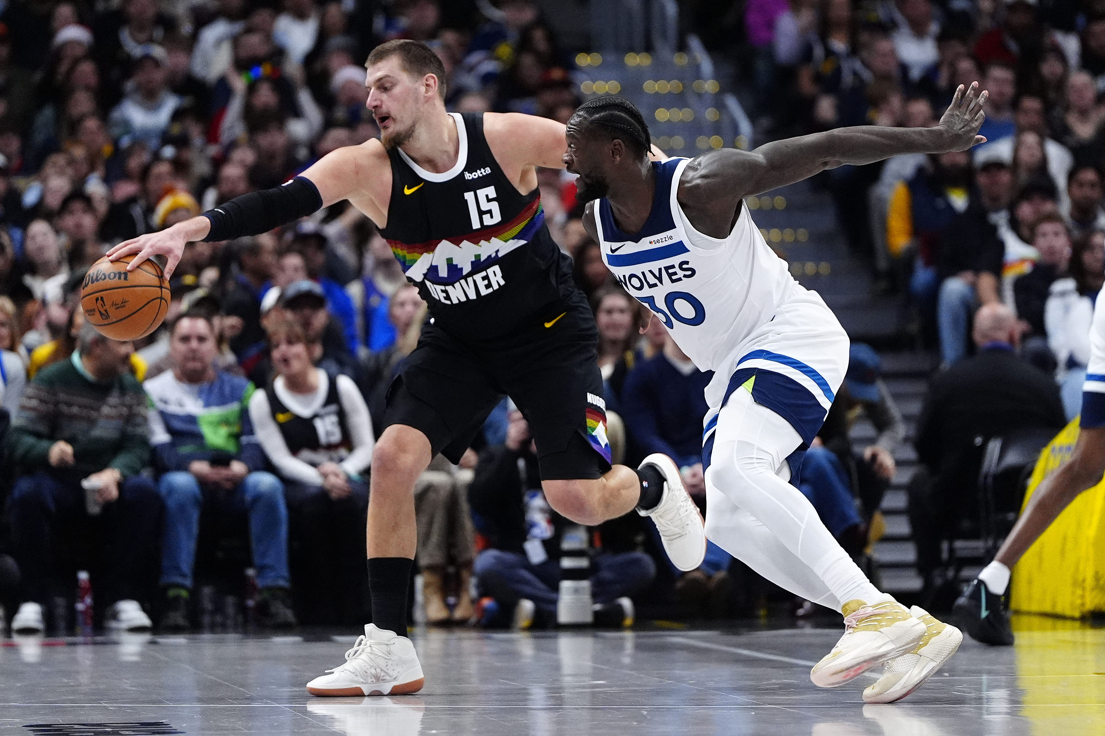 Denver Nuggets centre Nikola Jokic, left, and Minnesota Timberwolves forward Julius Randle battle for a loose ball during the first half at Ball Arena on December 25, 2025, in Denver, Colorado, US