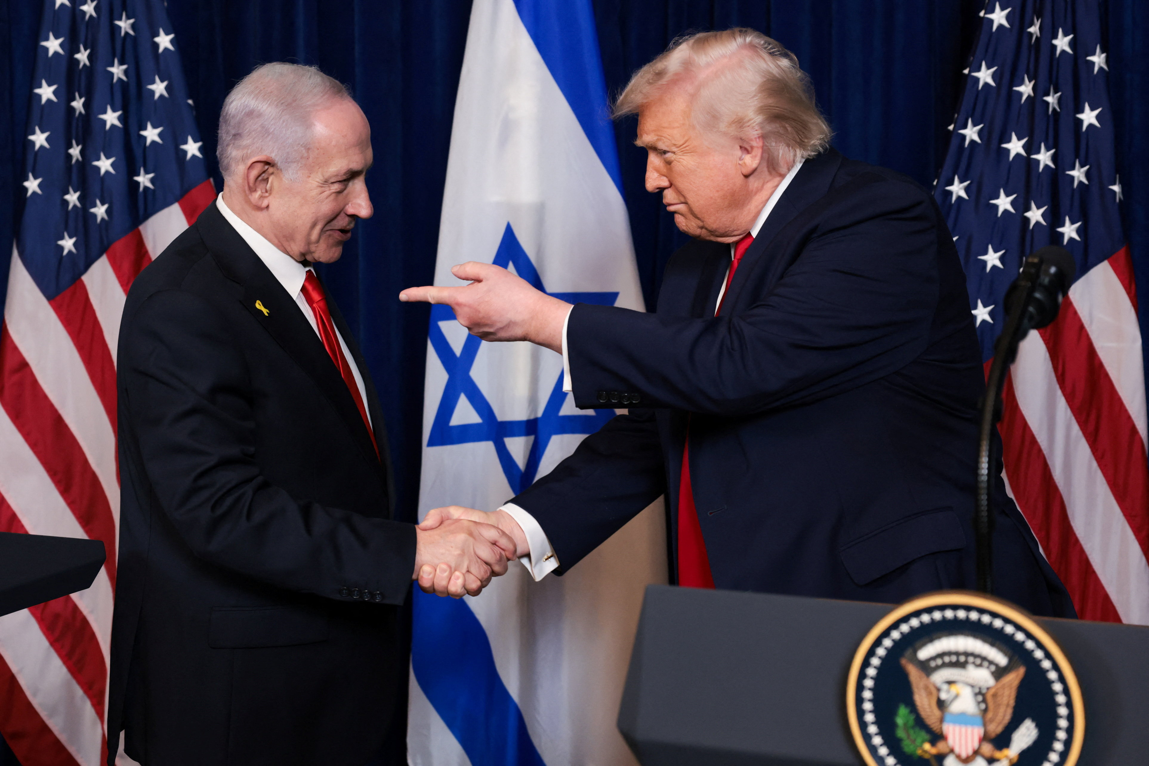 U.S. President Donald Trump points his finger towards Israeli Prime Minister Benjamin Netanyahu as they shake hands during a press conference after meeting at Trump’s Mar-a-Lago club in Palm Beach, Florida, U.S., December 29, 2025.