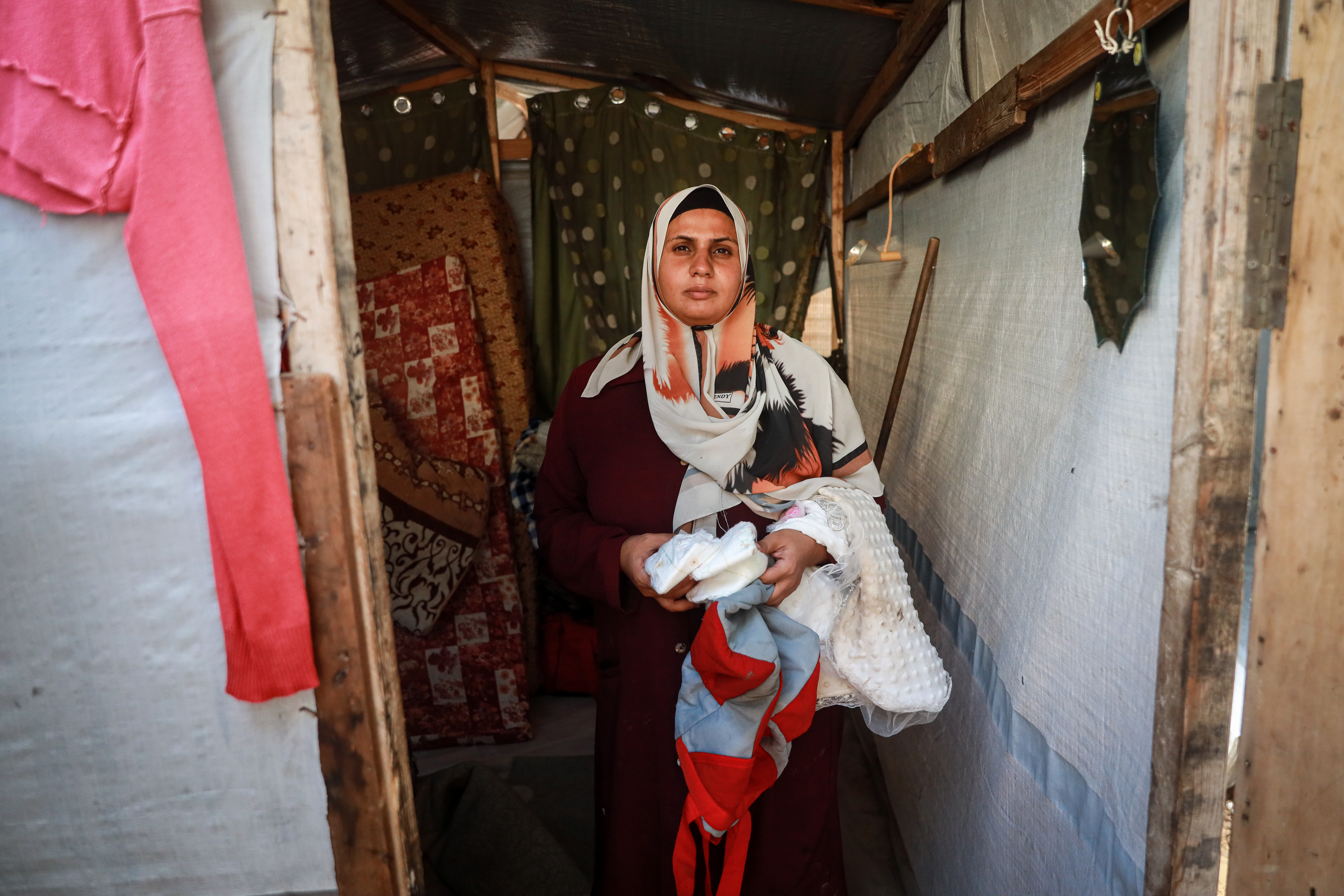 Salma al-Salmi cleans up her family’s rain-soaked tent