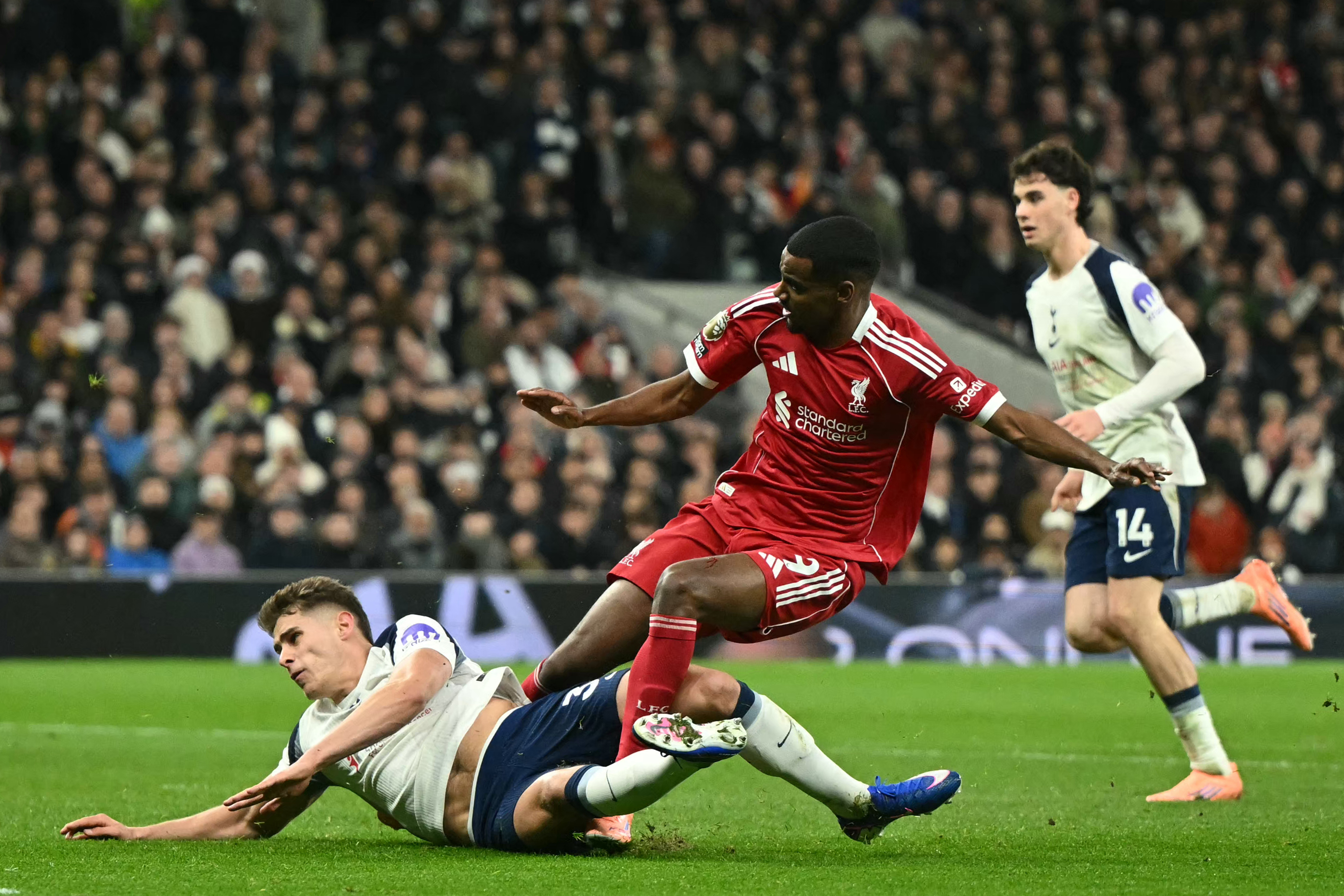 Isak, centre, gets injured in a challenge with Tottenham Hotspur’s Dutch defender #37 Micky van de Ven at the Tottenham Hotspur Stadium in London, on December 20, 2025