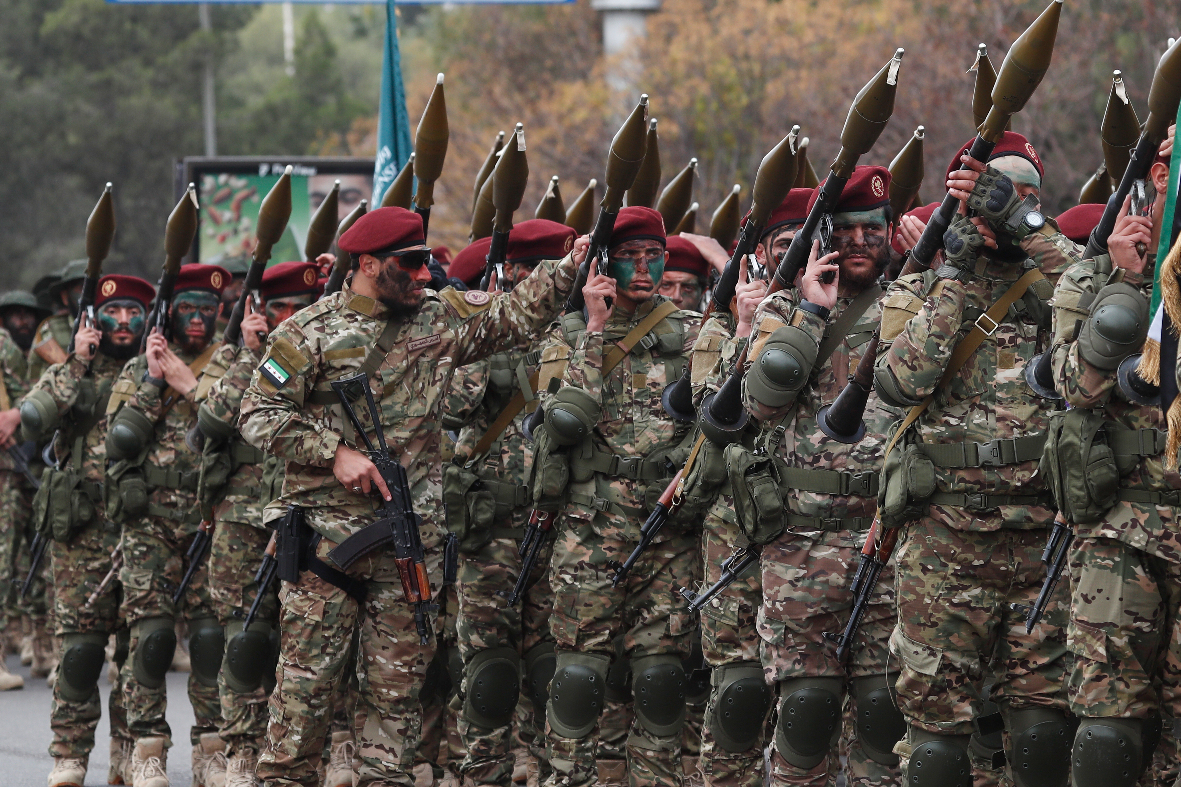 Fighters from the new Syrian army march with rocket-propelled grenade launchers during a parade