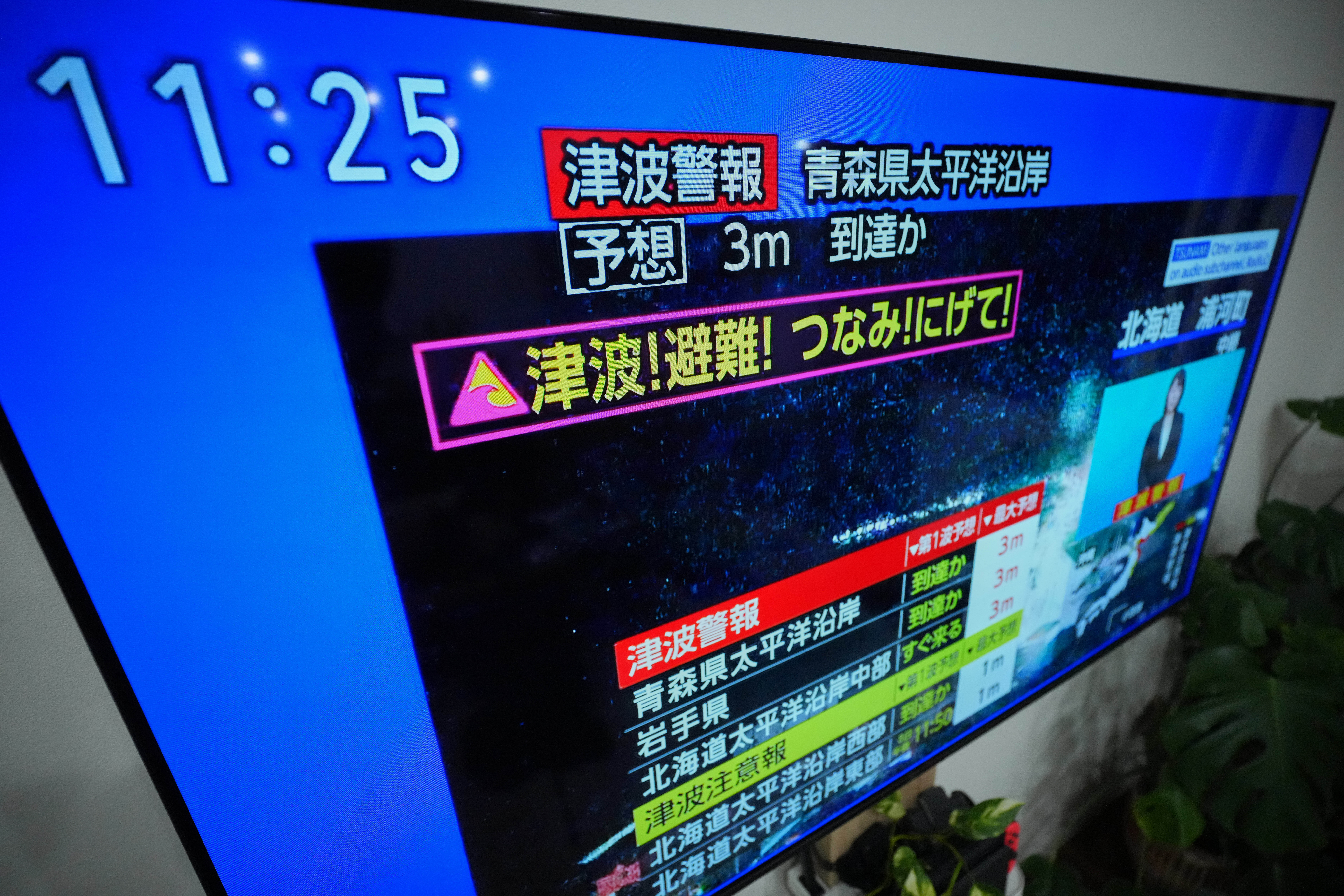 A tsunami warning is displayed on a television in Yokohama