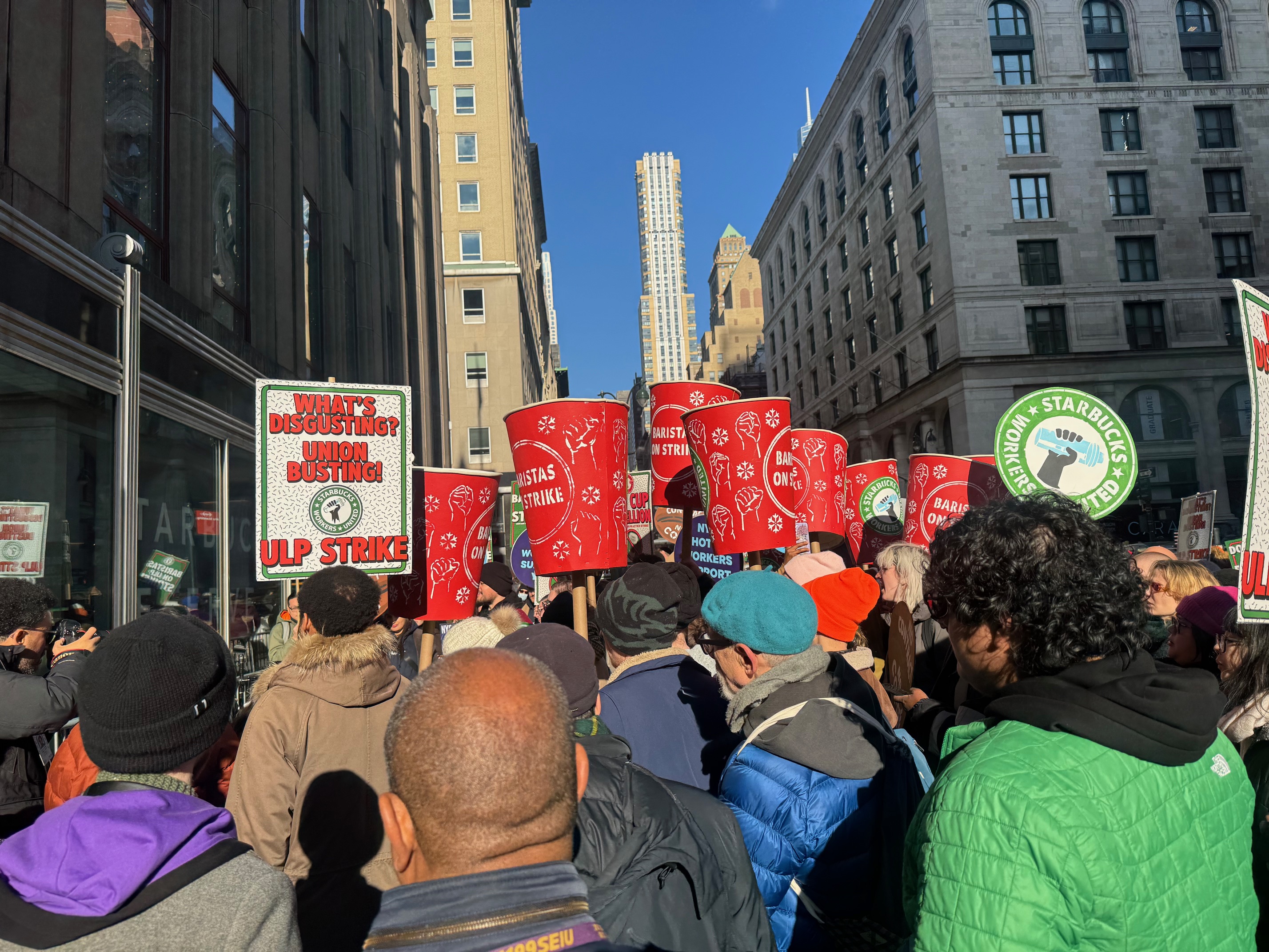 Starbucks alleges that there 25 Starbucks unionised workers alongside supporters, while Starbucks Workers United said that at least 100 baristas were present at Thursday’s rally in New York [Andy Hirschfeld/Al Jazeera]