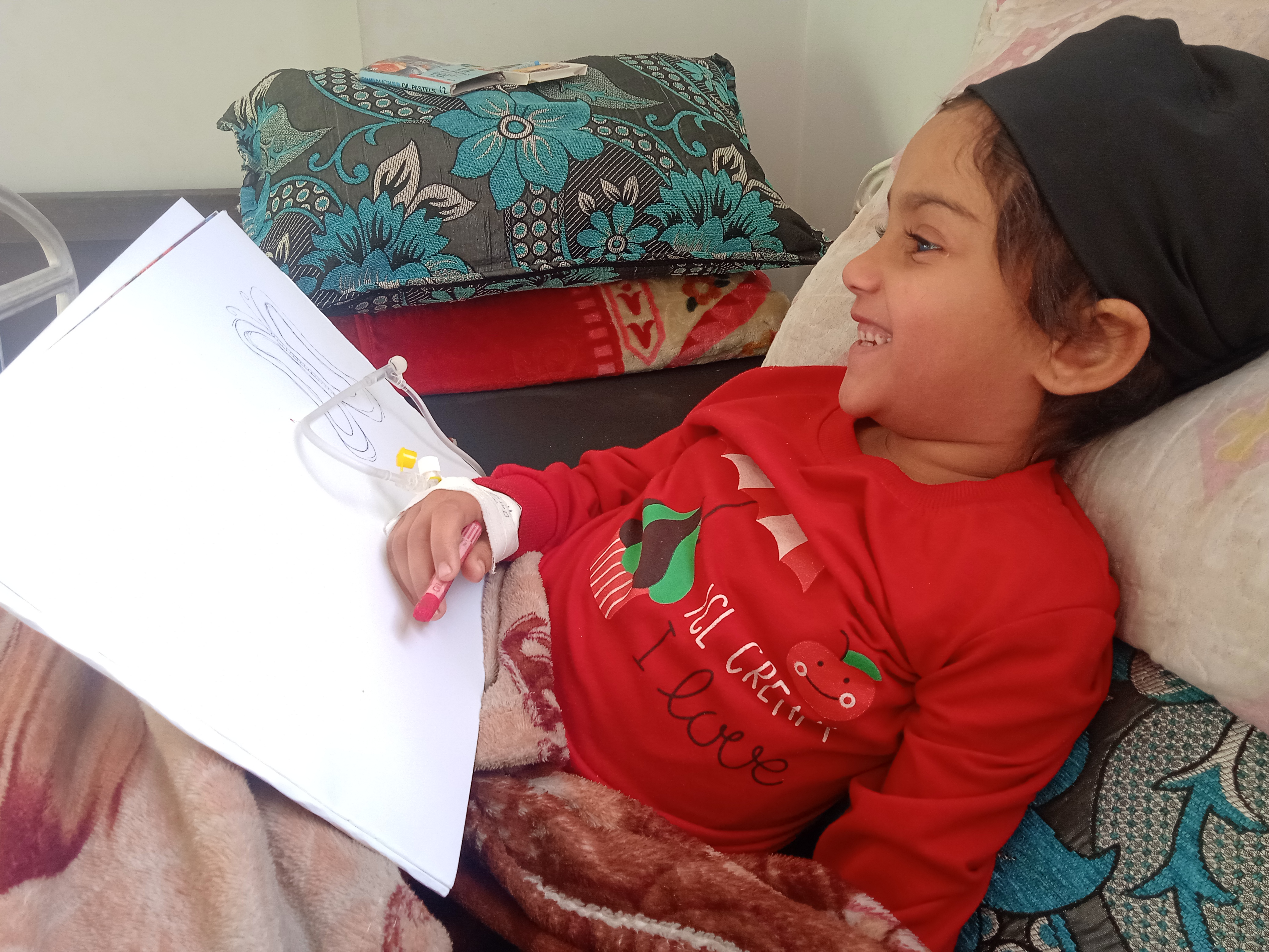 Sudnus trying to draw on the hospital bed [Courtesy of Eman Hillis]