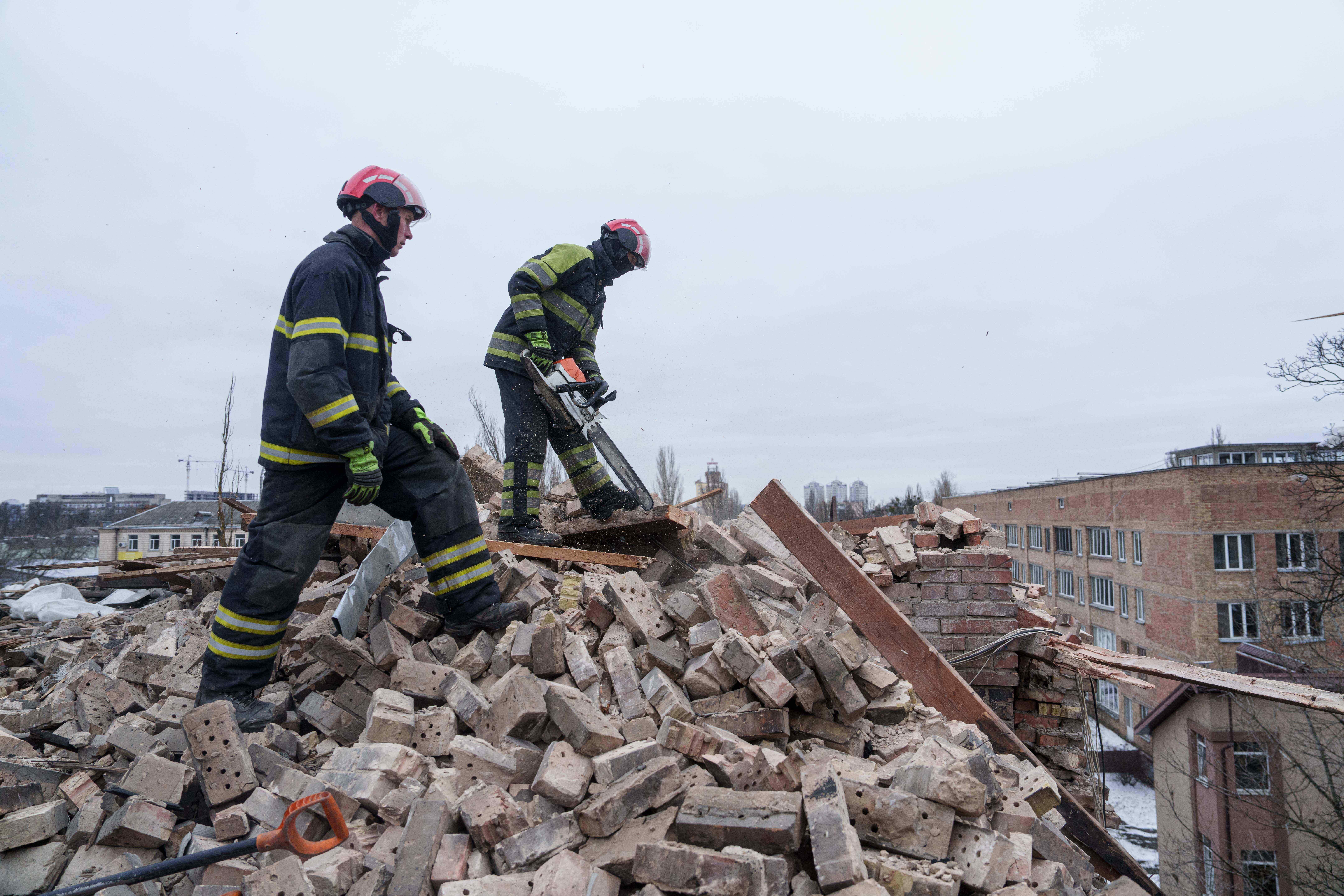 Rescue workers clear the rubble at the roof of apartment building damaged after a Russian strike on Kyiv, Ukraine, on Saturday, Dec. 27, 2025. (AP Photo/Evgeniy Maloletka)