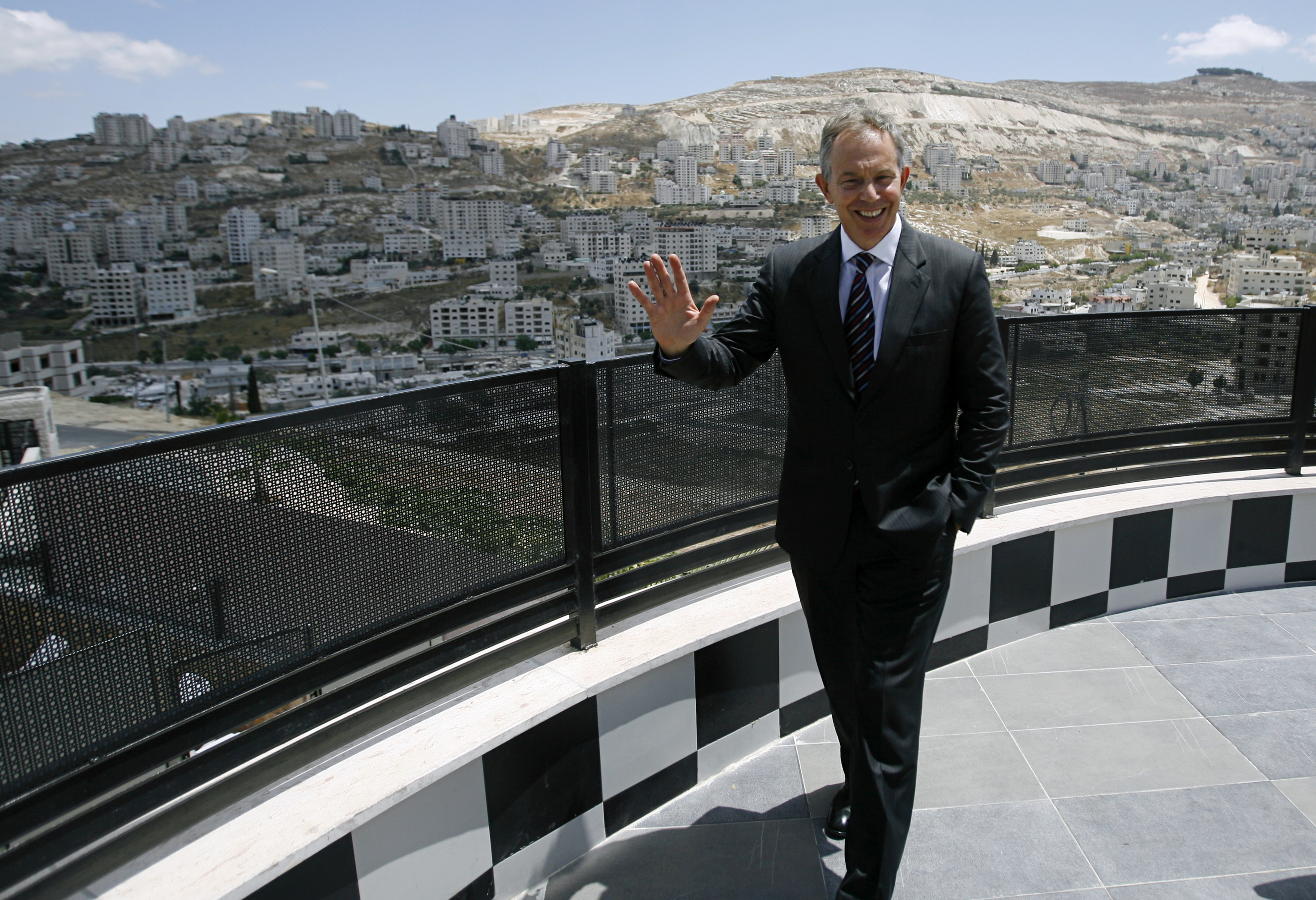Middle East envoy Tony Blair waves to the media during a visit to the West Bank city of Nablus July 14, 2009.