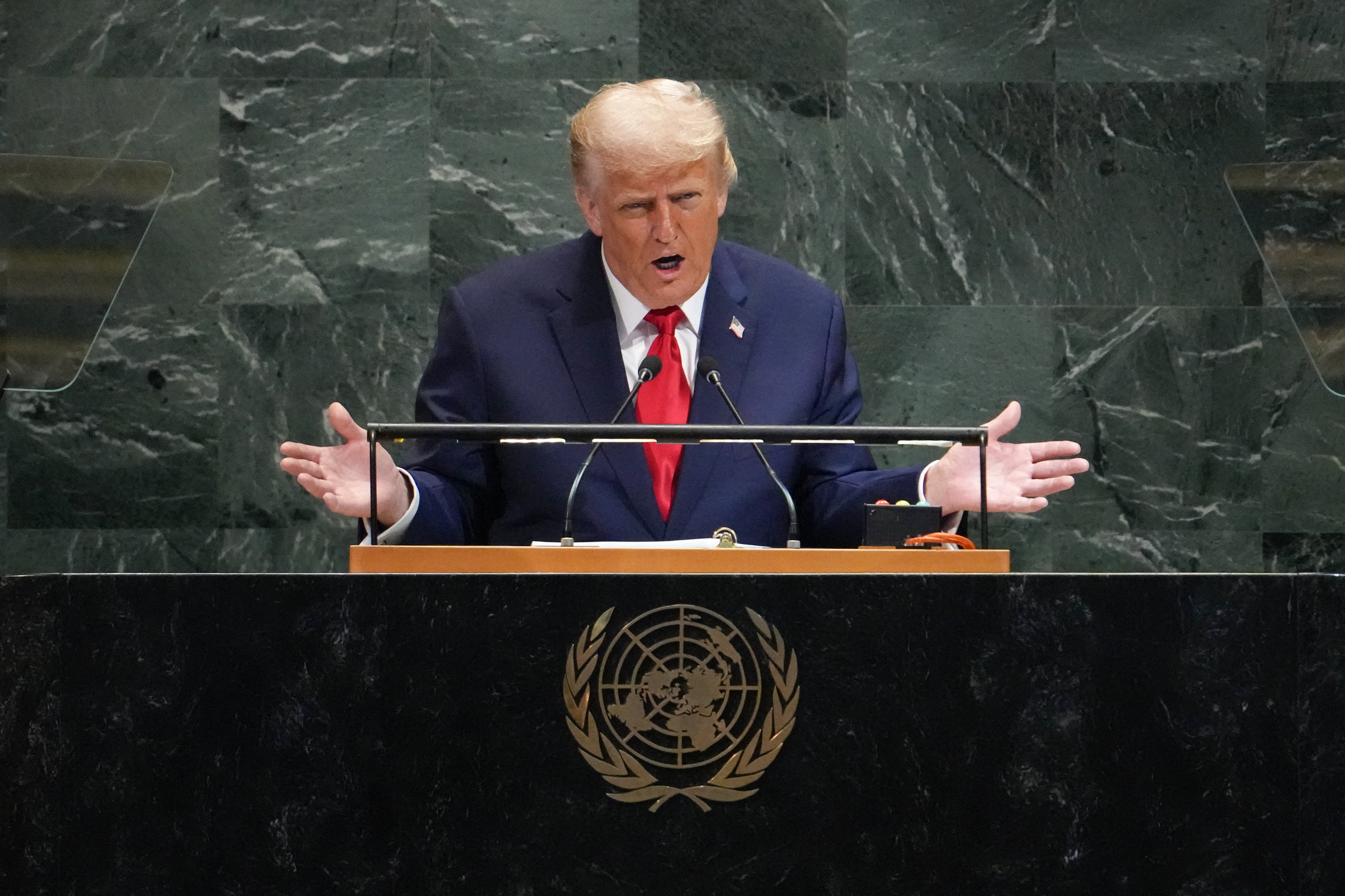 a man in a suit at a green marble podium