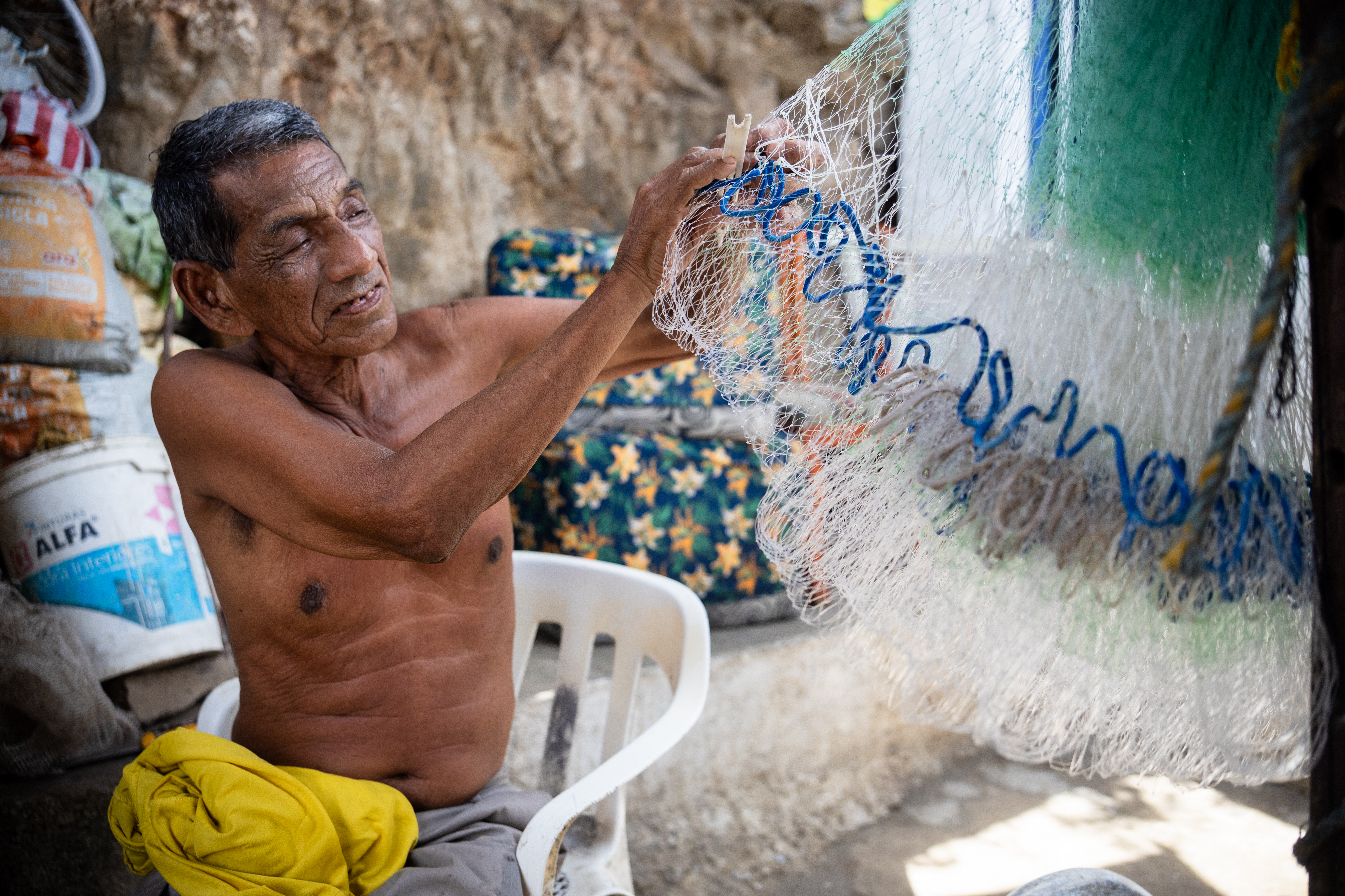 Alejandro Carranza, the father, fixes fishing nets