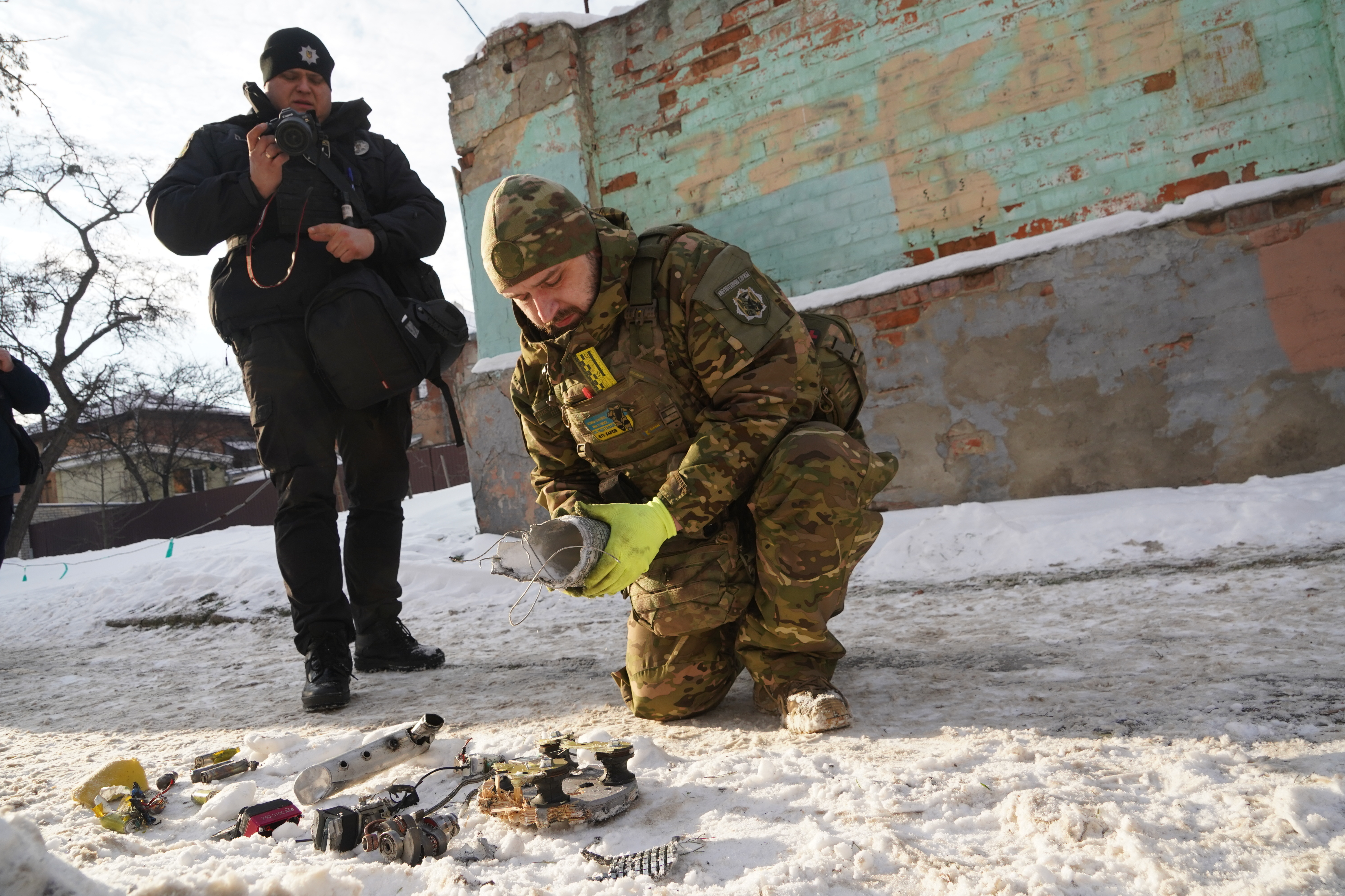 A sapper inspects fragments of a Russian drone that hit near the city hospital in Kharkiv, Ukraine, Monday, Jan. 19, 2026. (AP Photo/Andrii Marienko)