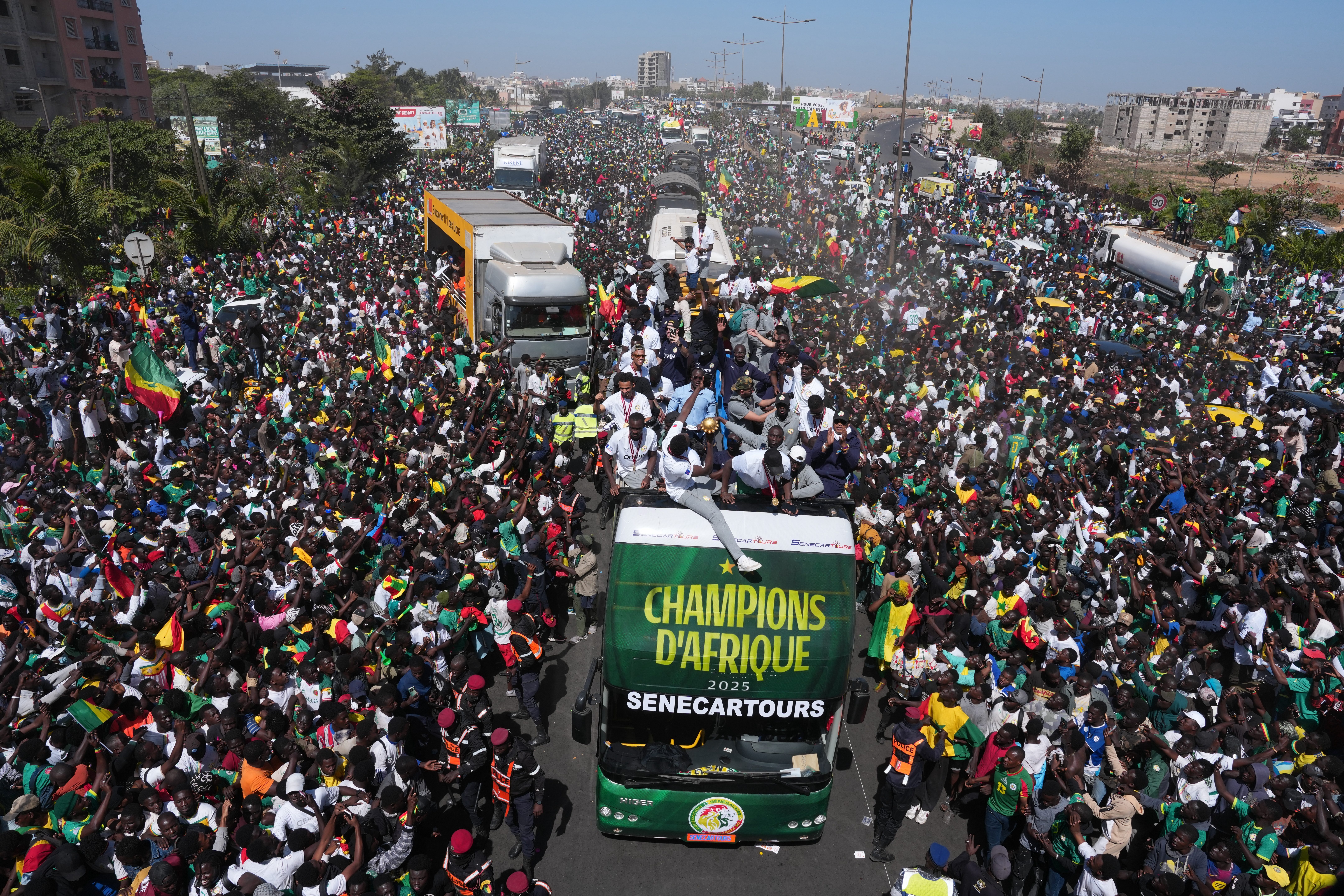The Senegalese soccer team rides through thousands of cheering fans celebrating their victory in the Africa Cup of Nations soccer tournament, in Dakar, Senegal
