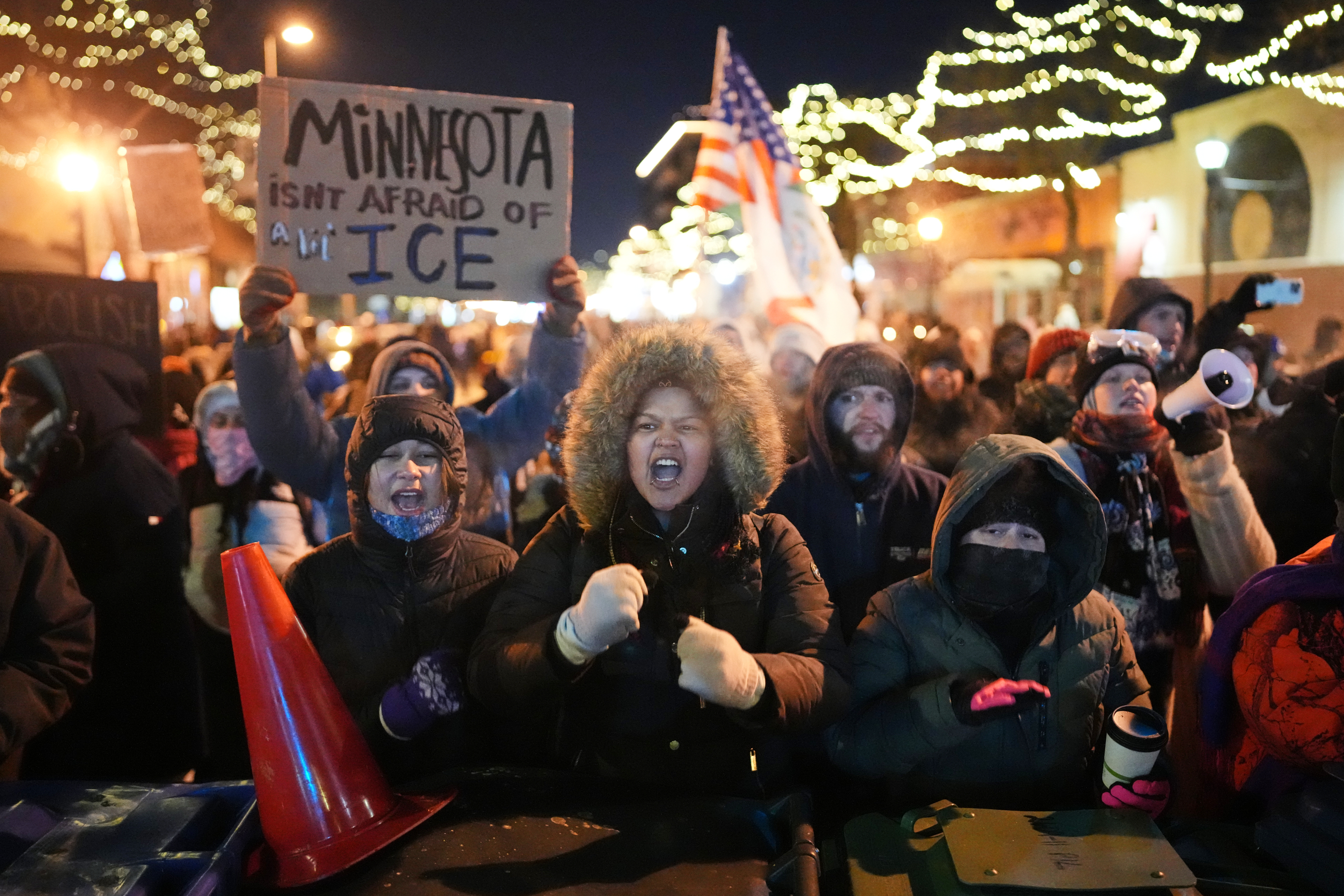 Protesters chant and bang on trash cans as they stand behind a makeshift barricade during a protest in response to the death of 37-year-old Alex Pretti, who was fatally shot by a U.S. Border Patrol officer