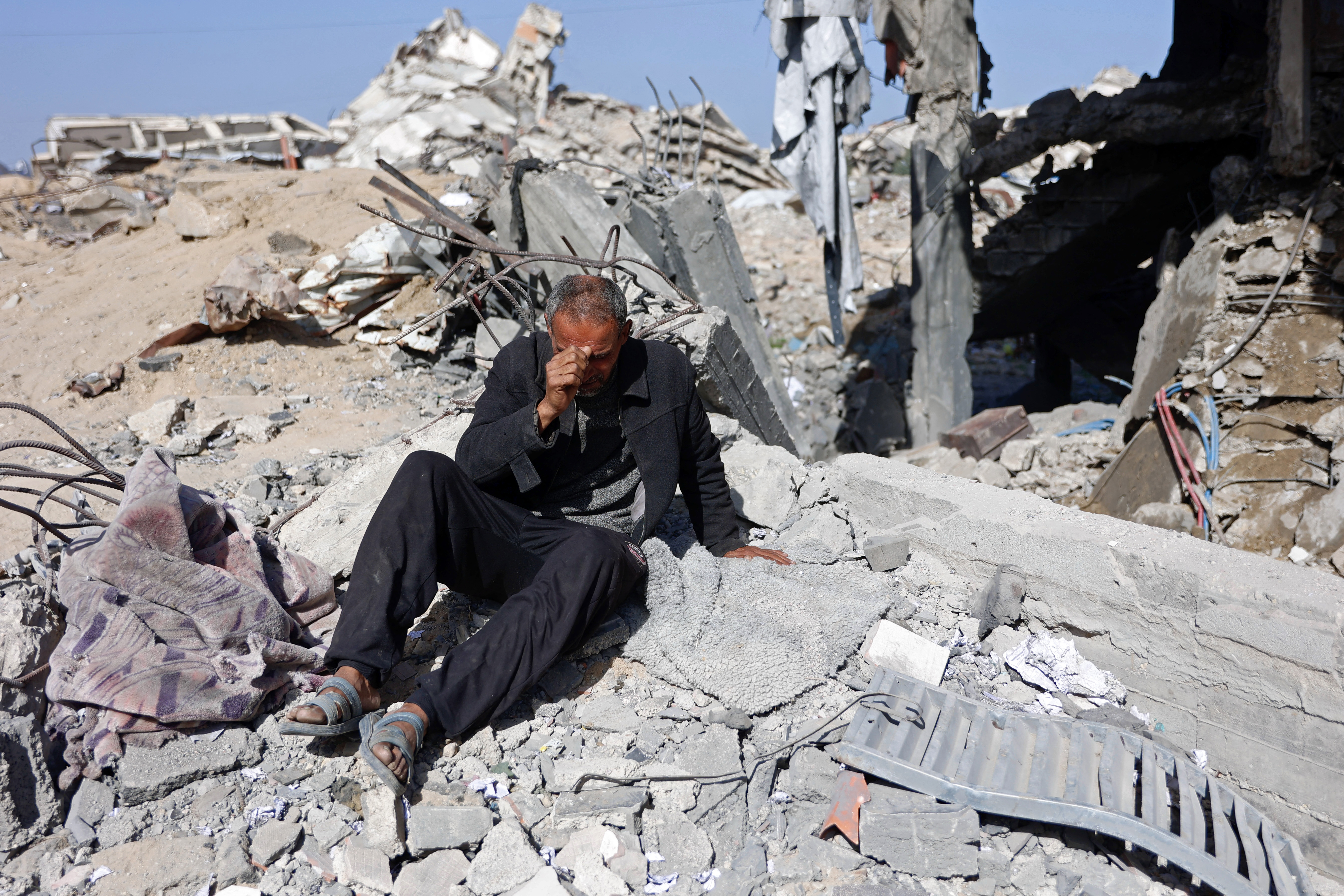 TOPSHOT - A man reacts while sitting amid the rubble of Sheikh Radwan police station in Gaza City on January 31, 2026, following an Israeli air strike.