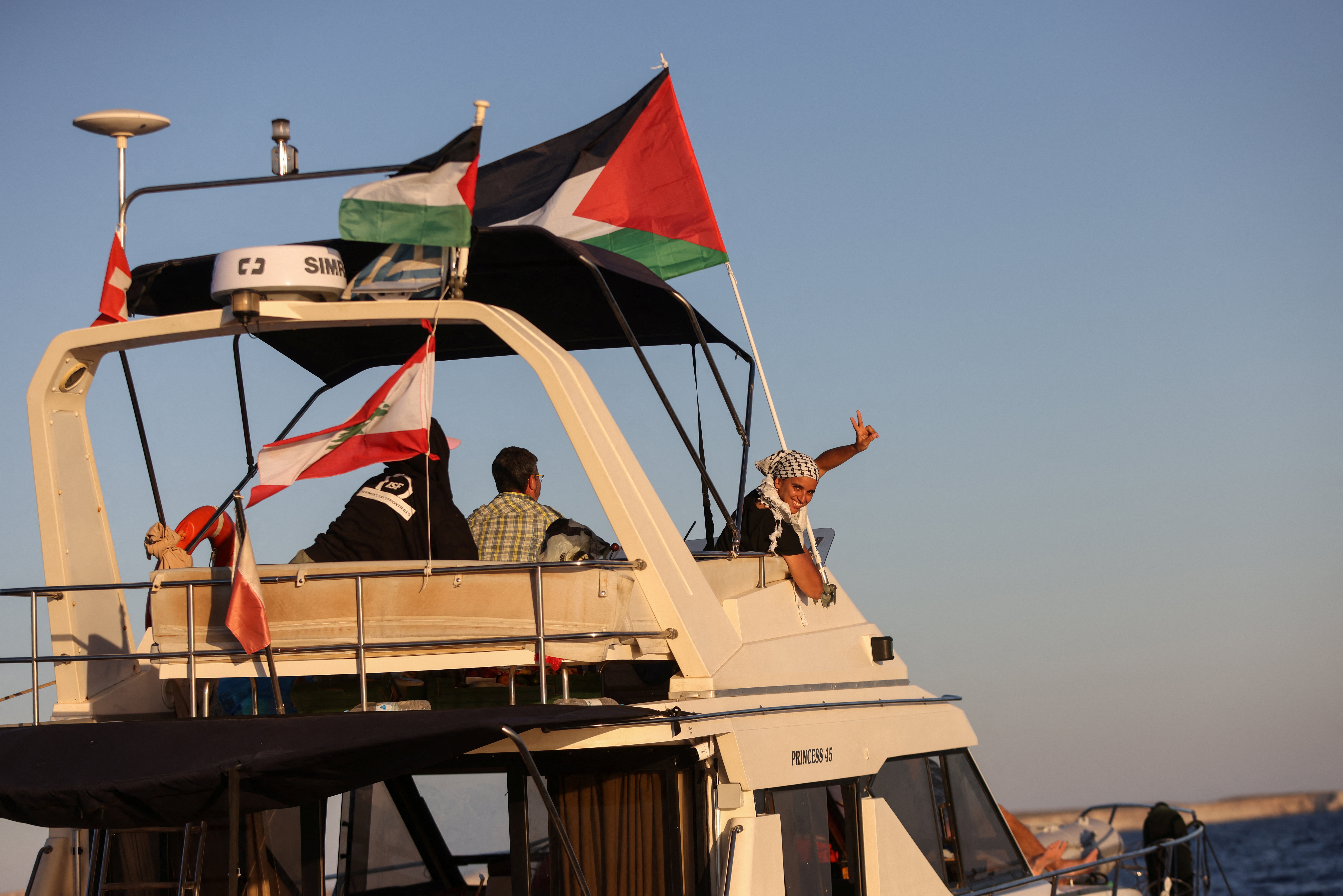 A woman gesture aboard a boat, part of the Global Sumud Flotilla aiming to reach Gaza and break Israel's naval blockade, as it sails off Crete island, Greece, September 25, 2025. REUTERS/Stefanos Rapanis