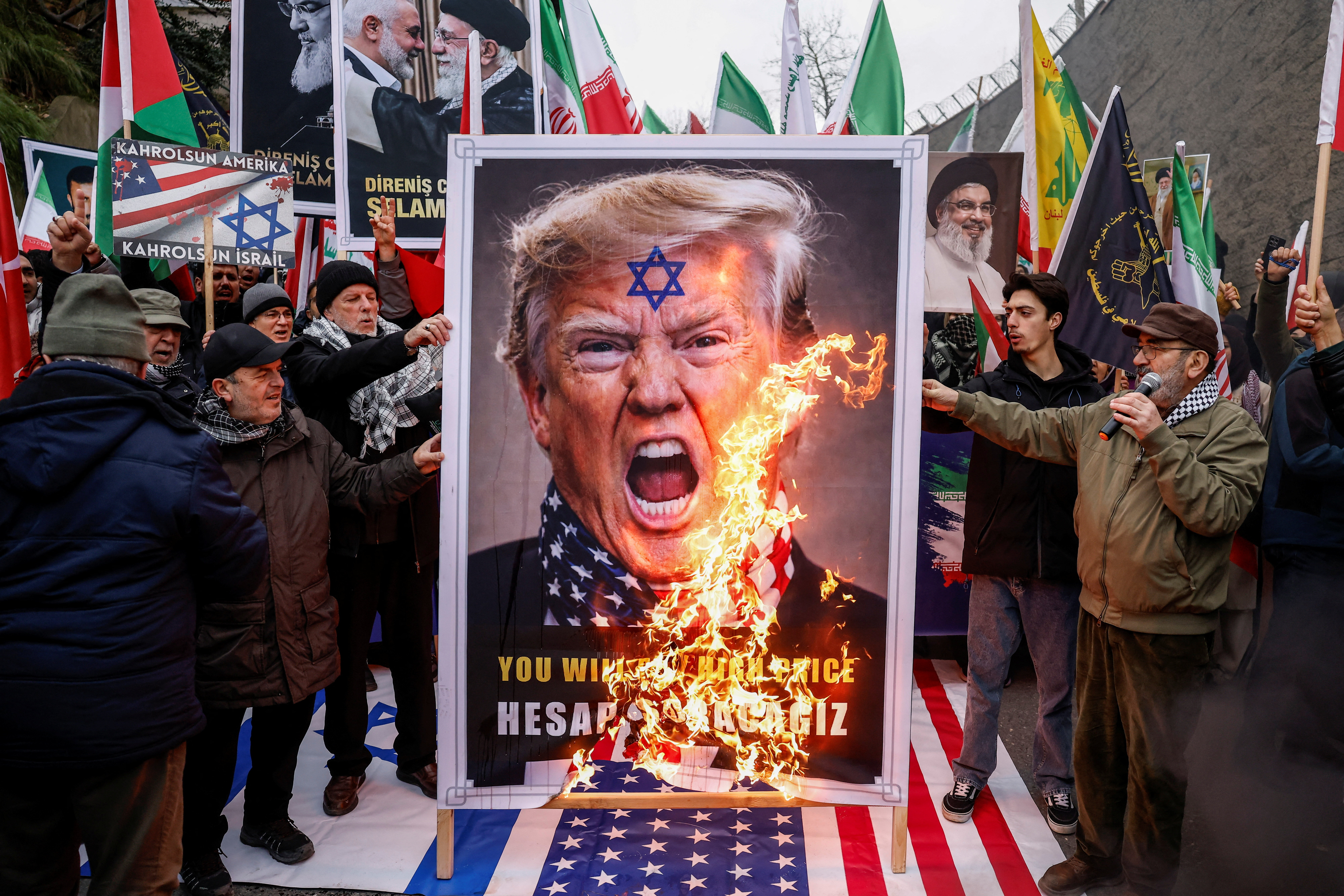 Demonstrators burn a poster of US President Donald Trump.