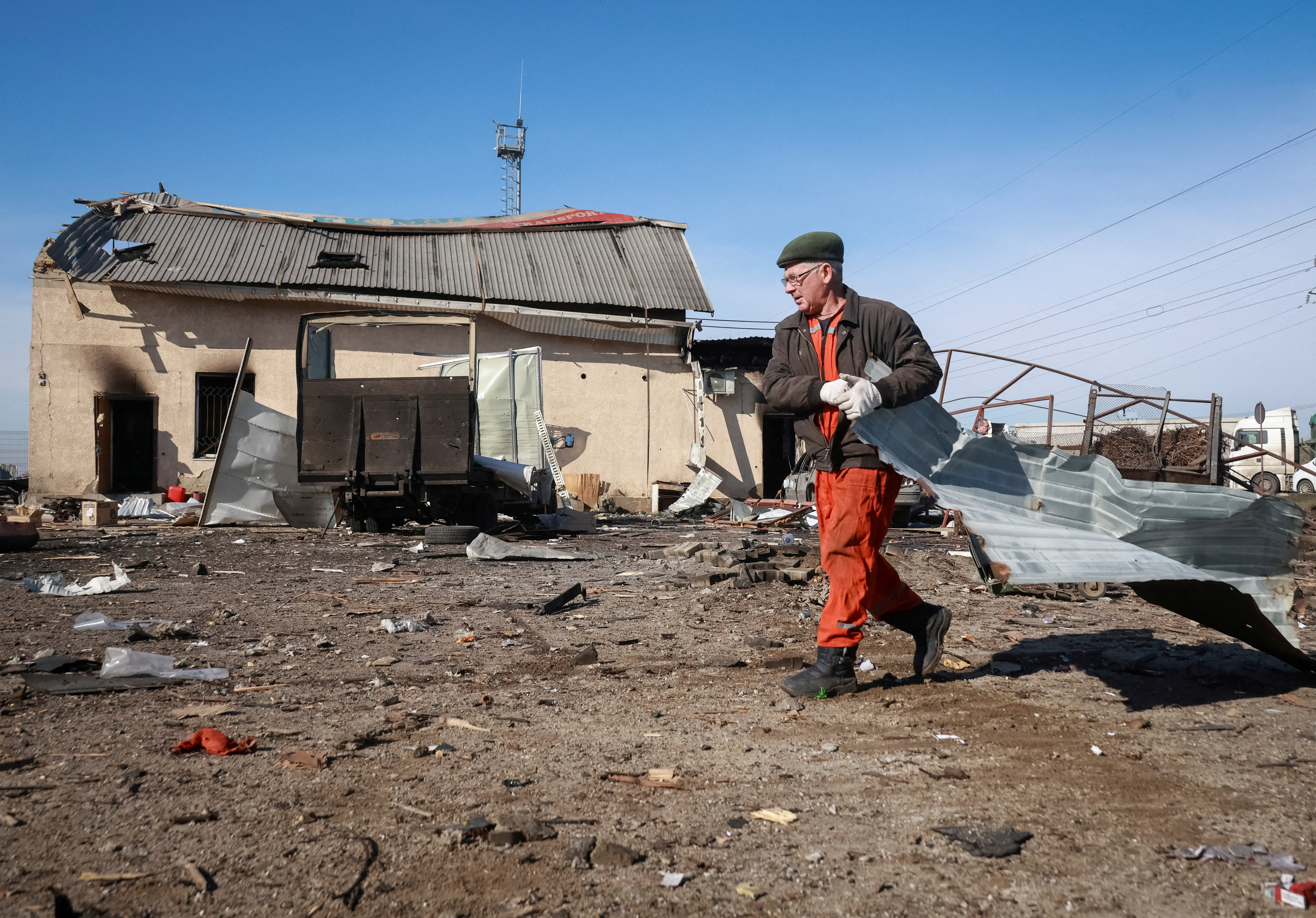 A resident cleans an area at the site of a drone attack.