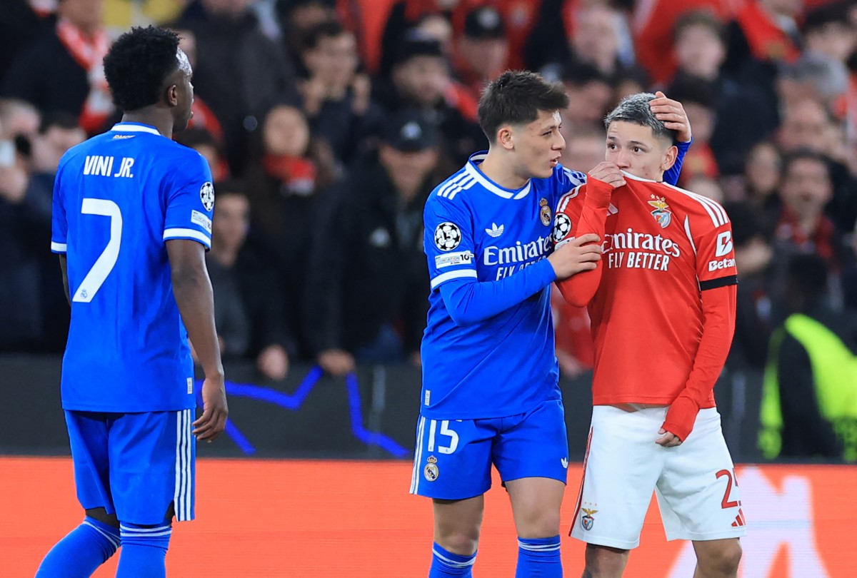 Benfica's Argentine forward #25 Gianluca Prestianni hides his mouth while arguing with Real Madrid's Brazilian forward #07 Vinicius Junior
