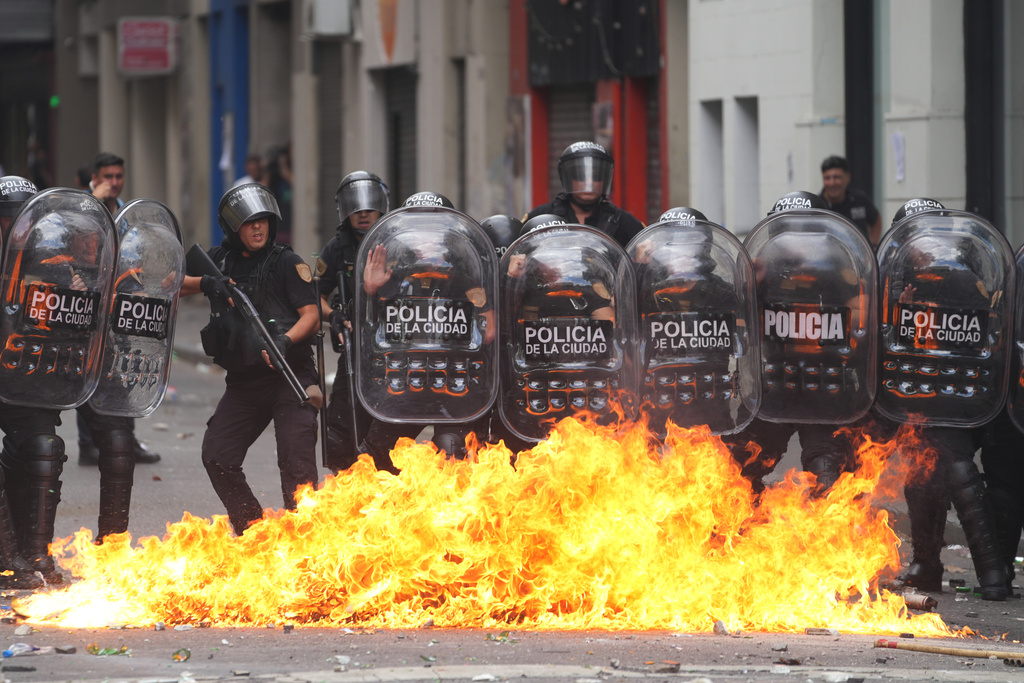 A molotov cocktail explodes near a group of riot police