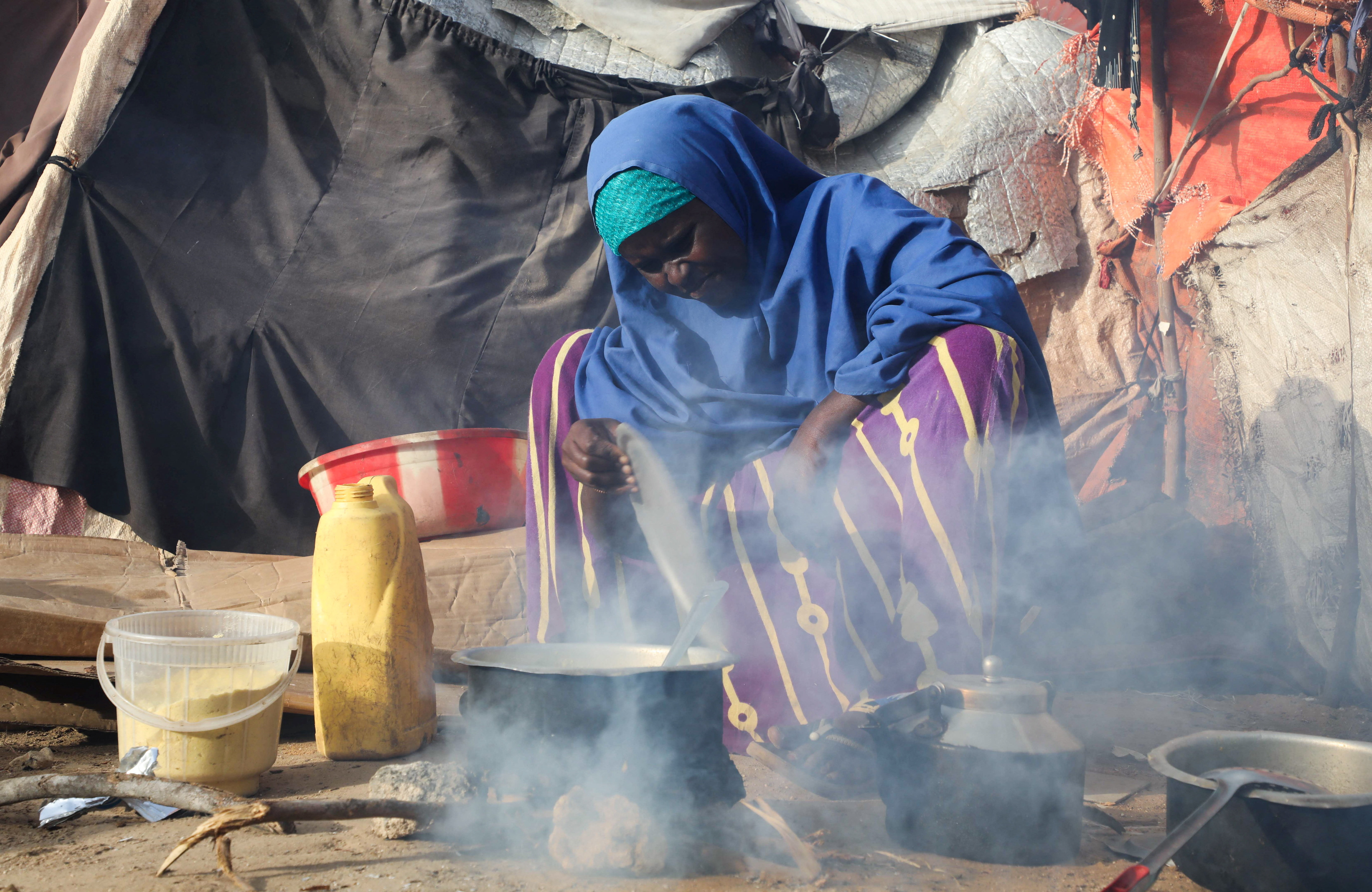 An internally displaced Somali woman prepares porridge for Iftar