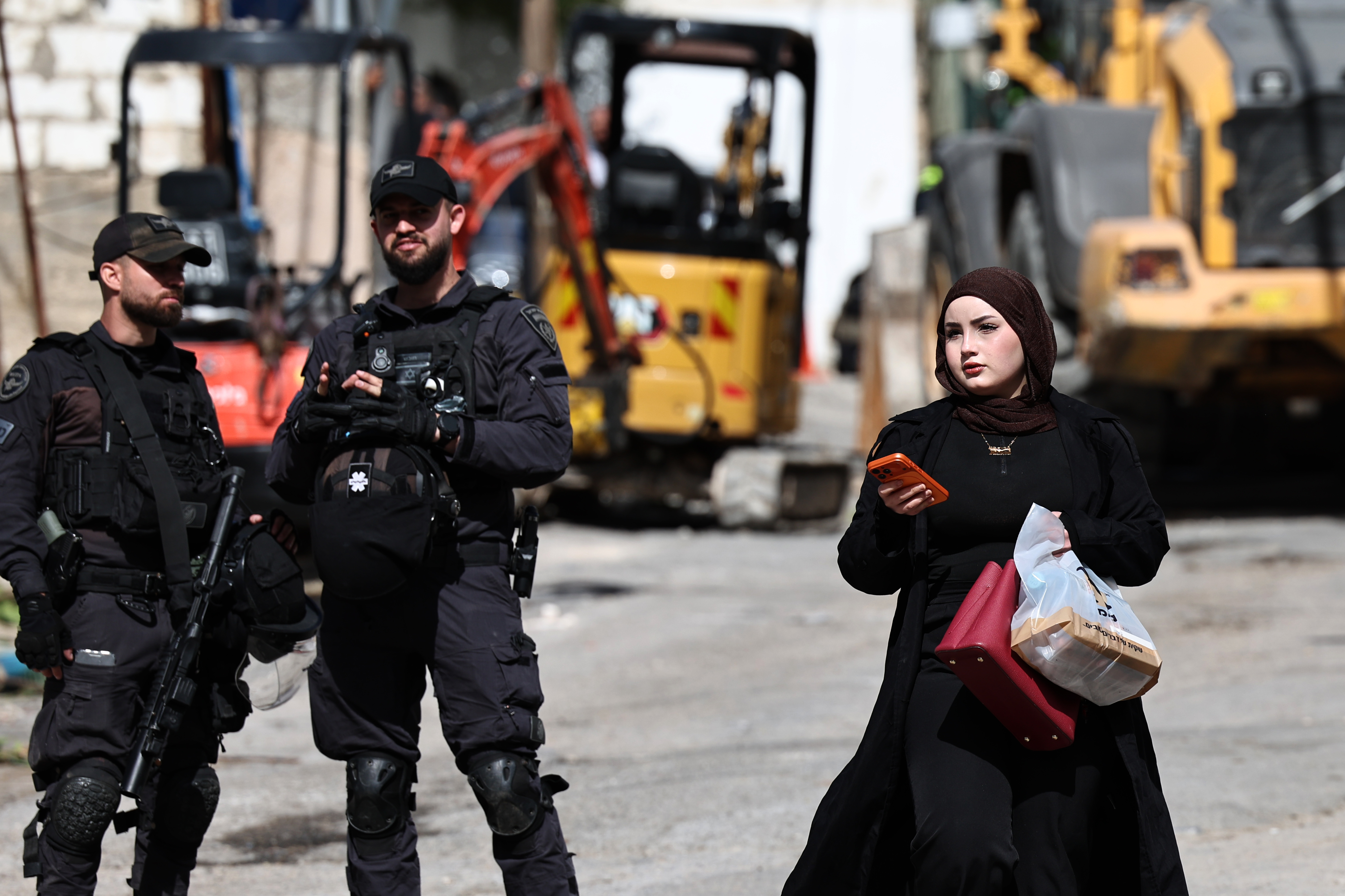 epa12723539 A Palestinian resident passes police officers in the Silwan neighborhood in east Jerusalem during a property demolition operation in Jerusalem, 10 February 2006. According to the Jerusalem Governorate of the Palestinian Authorities, Israel issued a demolition notice for more than 21 Palestinian homes in the al-Bustan neighborhood of Silwan, south of the Al-Aqsa Mosque in East Jerusalem. EPA/ATEF SAFADI