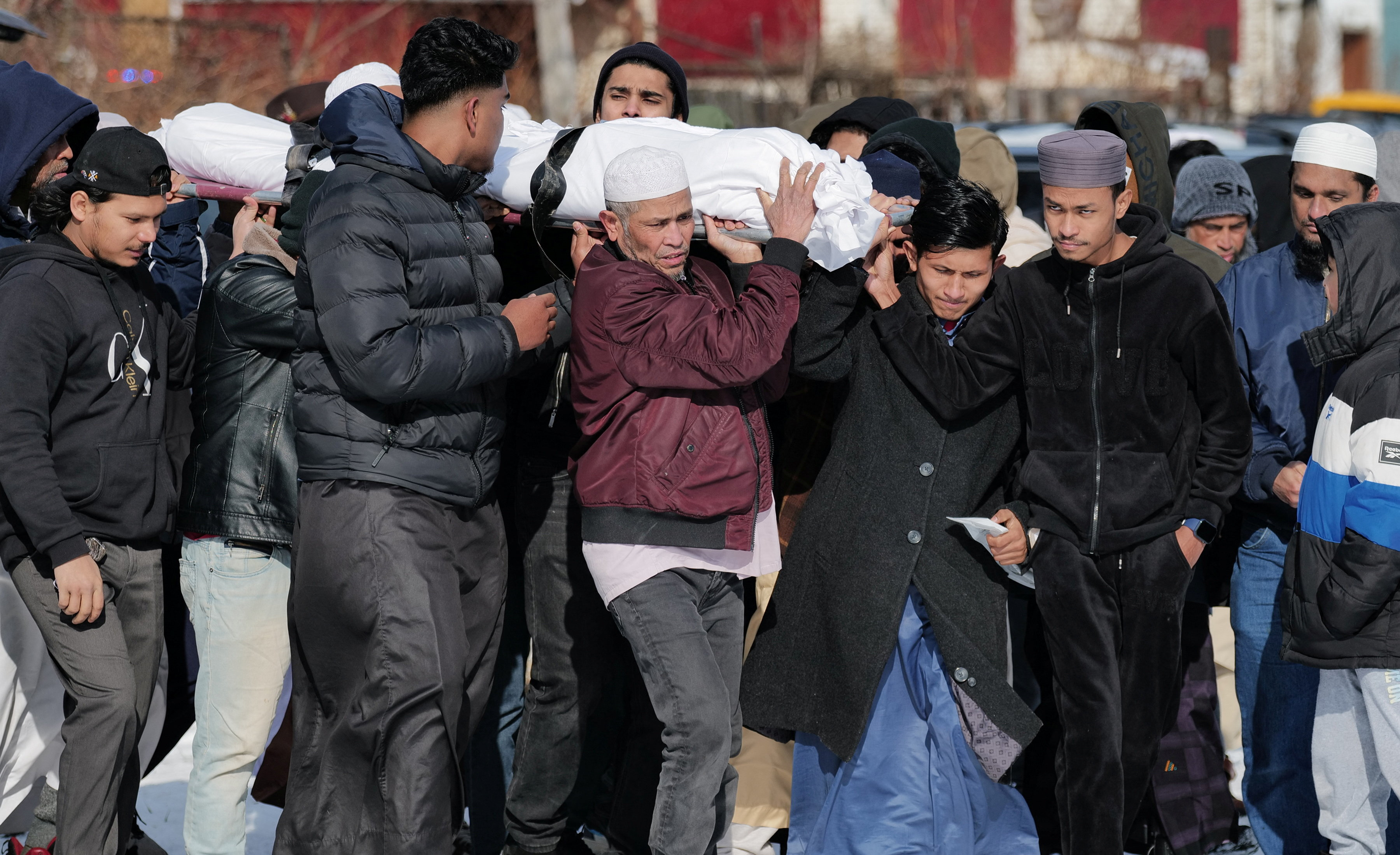 Community members and loved ones carry the body of Nurul Amin Shah Alam, a nearly blind refugee from Myanmar who was missing since his release from a jail into the custody of the U.S. Border Patrol, and who was later found dead, during his funeral service, in Buffalo, New York, U.S., February 26, 2026. REUTERS/Craig Ruttle