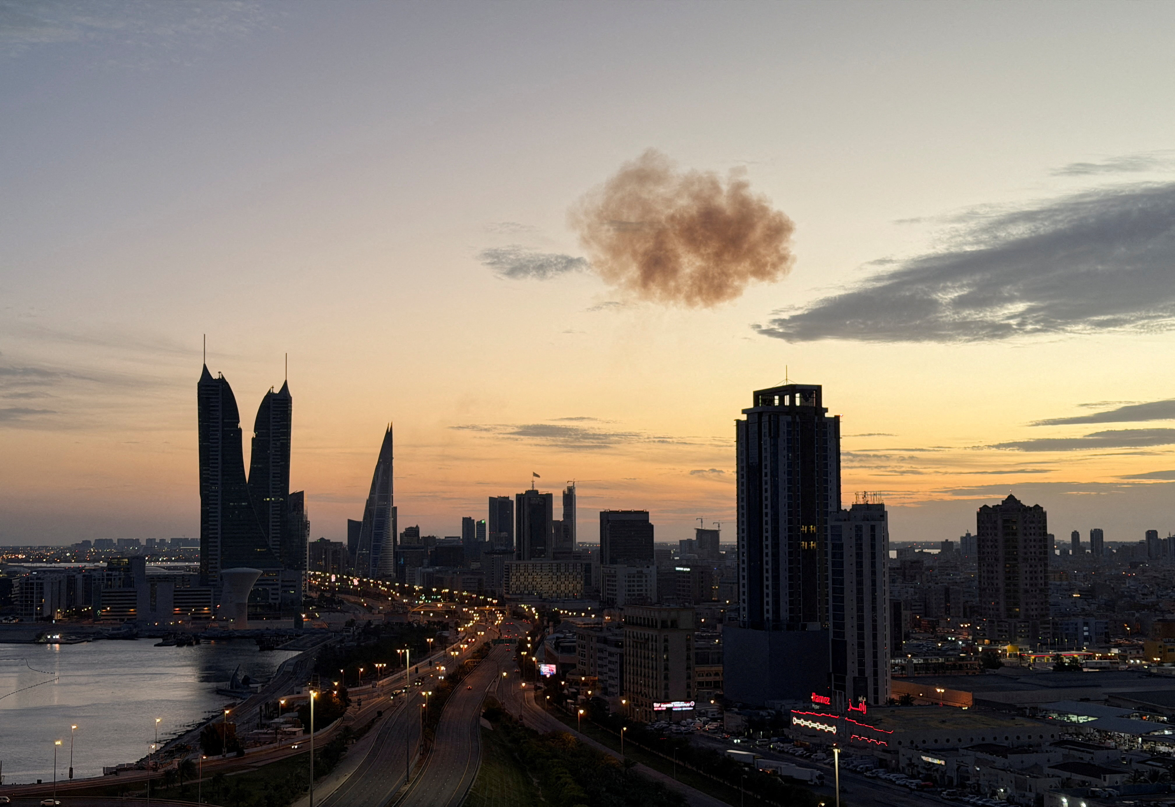 Smoke rises over a city skyline.