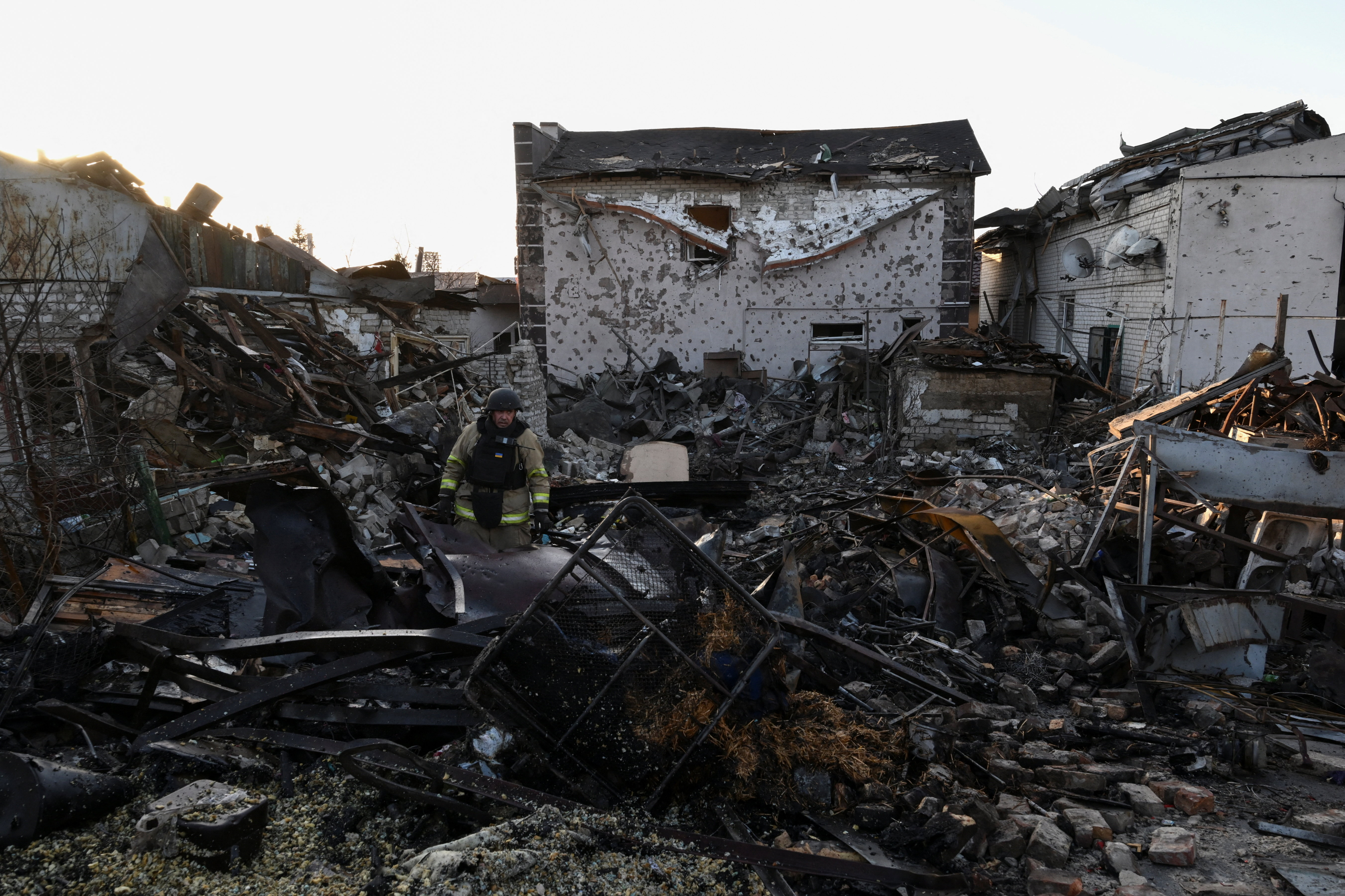 A firefighter inspects debris of a building destroyed by a Russian airstrike, amid Russia's attack on Ukraine, in Zaporizhzhia