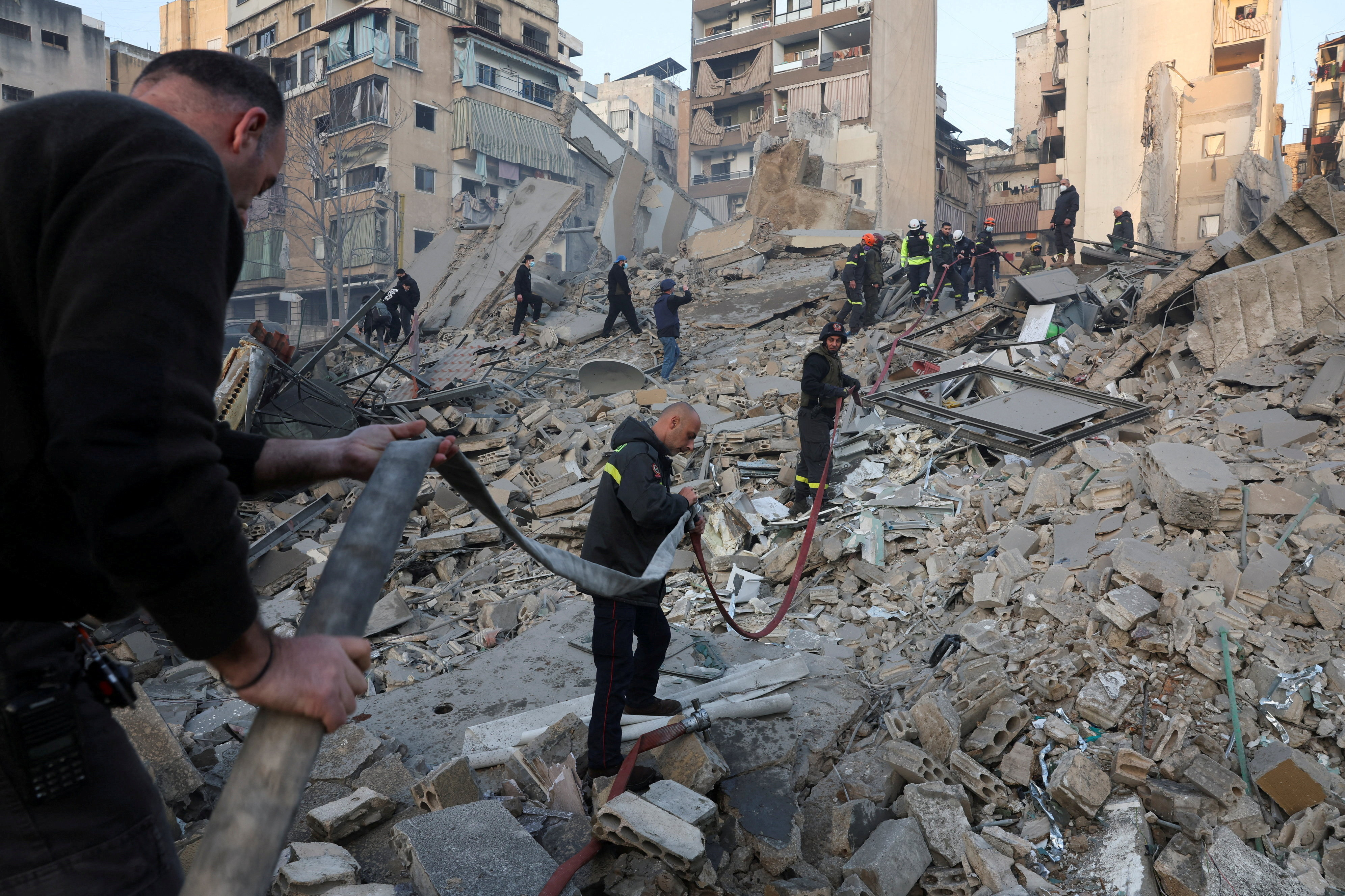 Emergency personnel work at the site of a collapsed building.