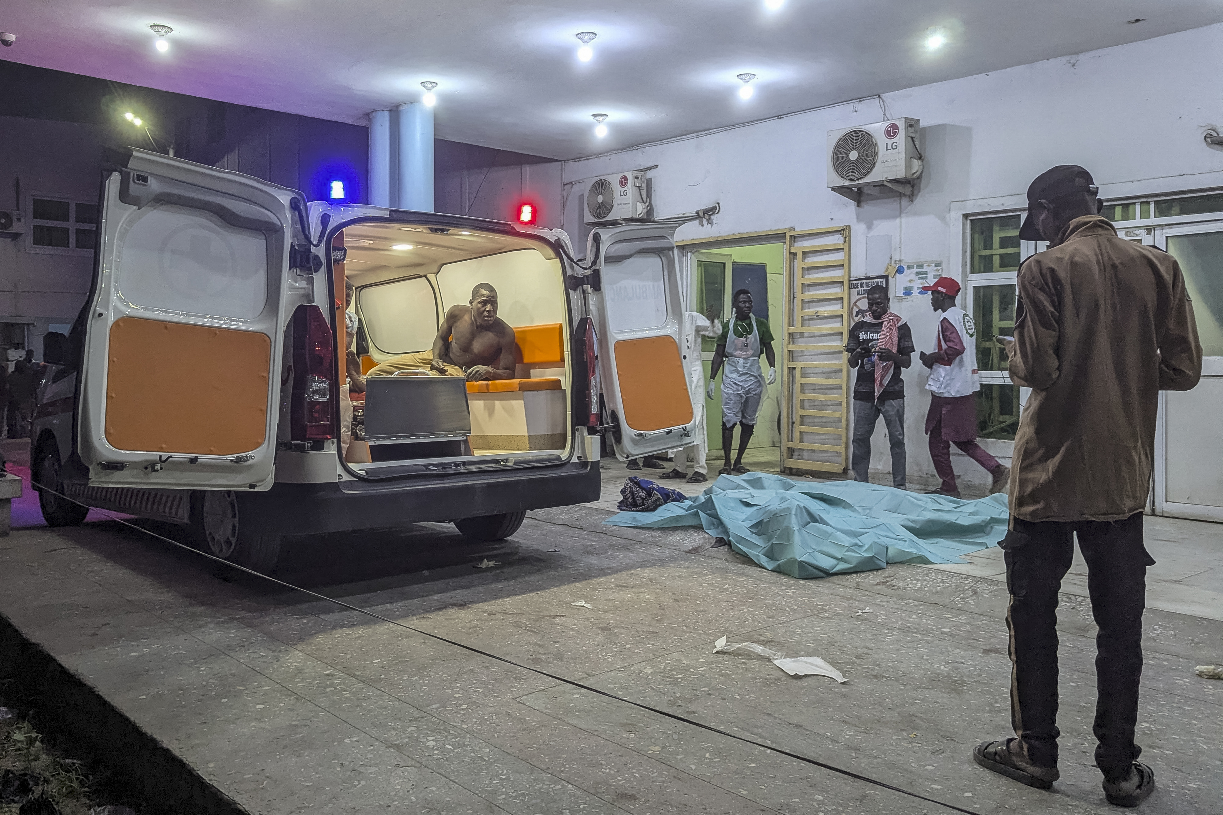 An injured man looks out of an ambulance at a hospital.