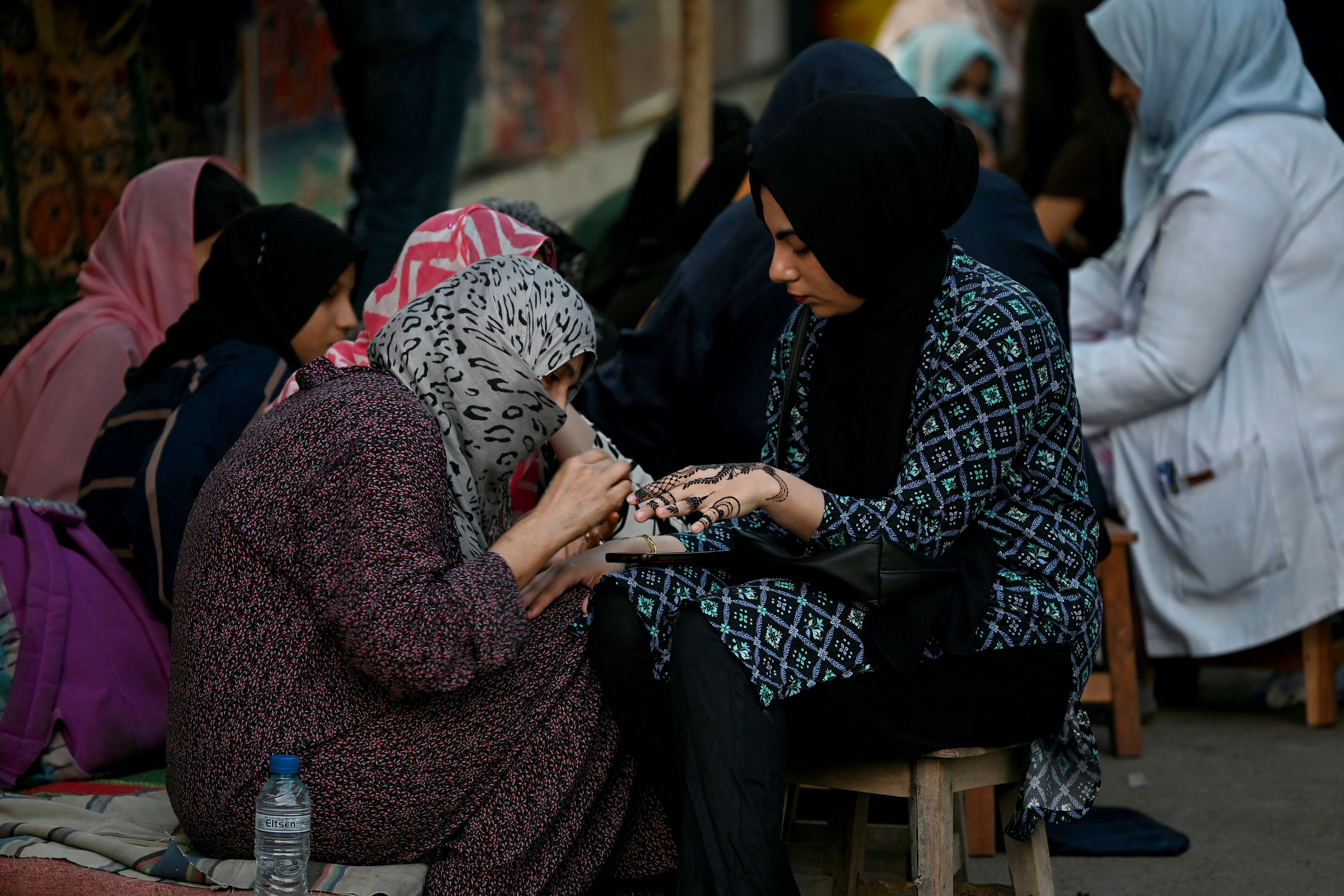 A woman gets her hands decorated with henna on the eve of the Muslim festival of Eid al-Fitr, in Karachi on March 19, 2026. (Photo by Rizwan TABASSUM / AFP)