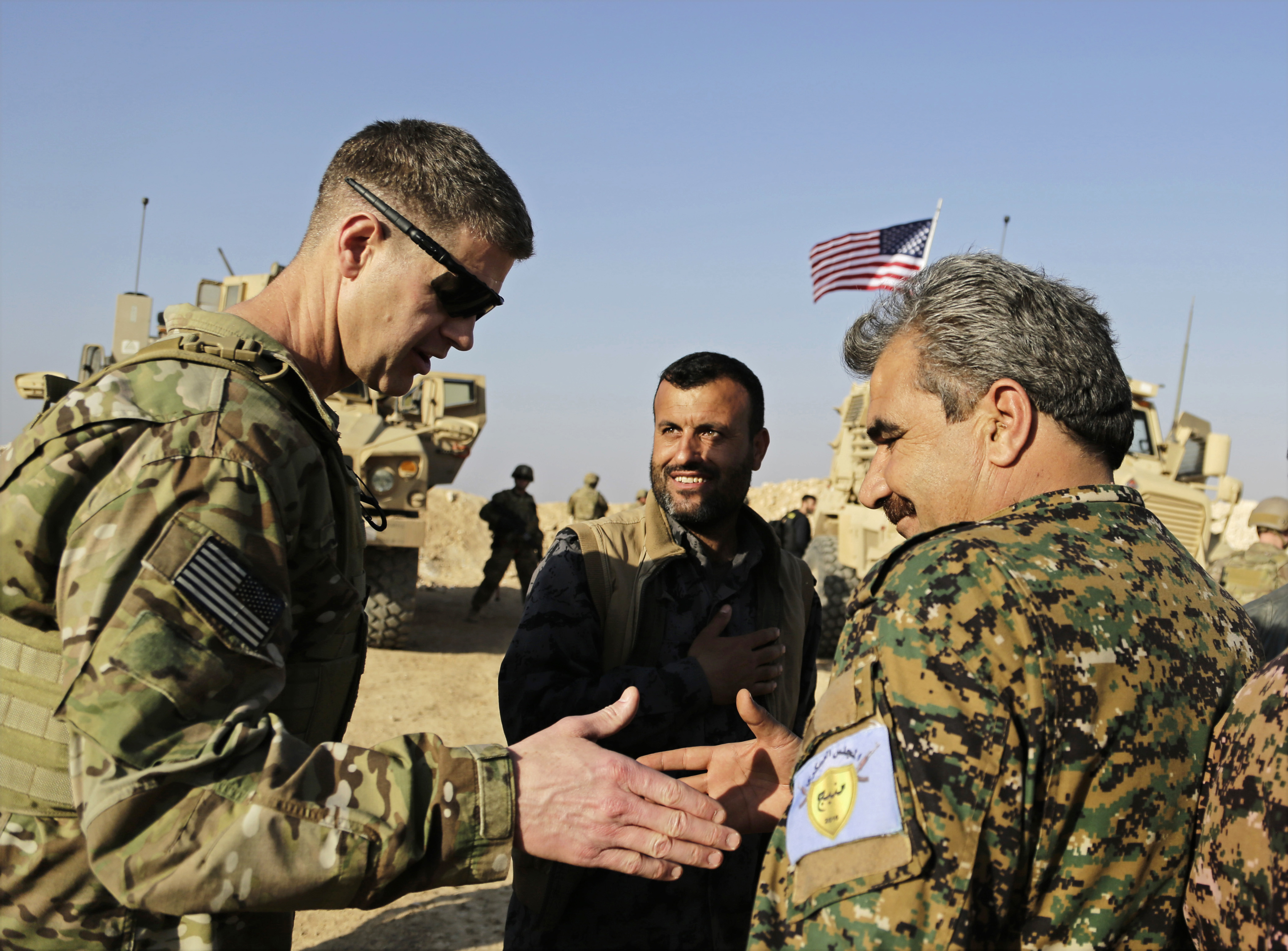 FILE - This Wednesday, Feb. 7, 2018 file photo, shows U.S. Army Maj. Gen. Jamie Jarrard left, thanks Manbij Military Council commander Muhammed Abu Adeel near the town of Manbij, northern Syria. As Syrian troops and their allies push toward final victory and the battle against Islamic State militants draws to an end, new fronts are opening up, threatening an even broader confrontation. The U.S., Israel and Turkey all have deepened their involvement, seeking to protect their interests in the new Syria order. (AP Photo/Susannah George, File)