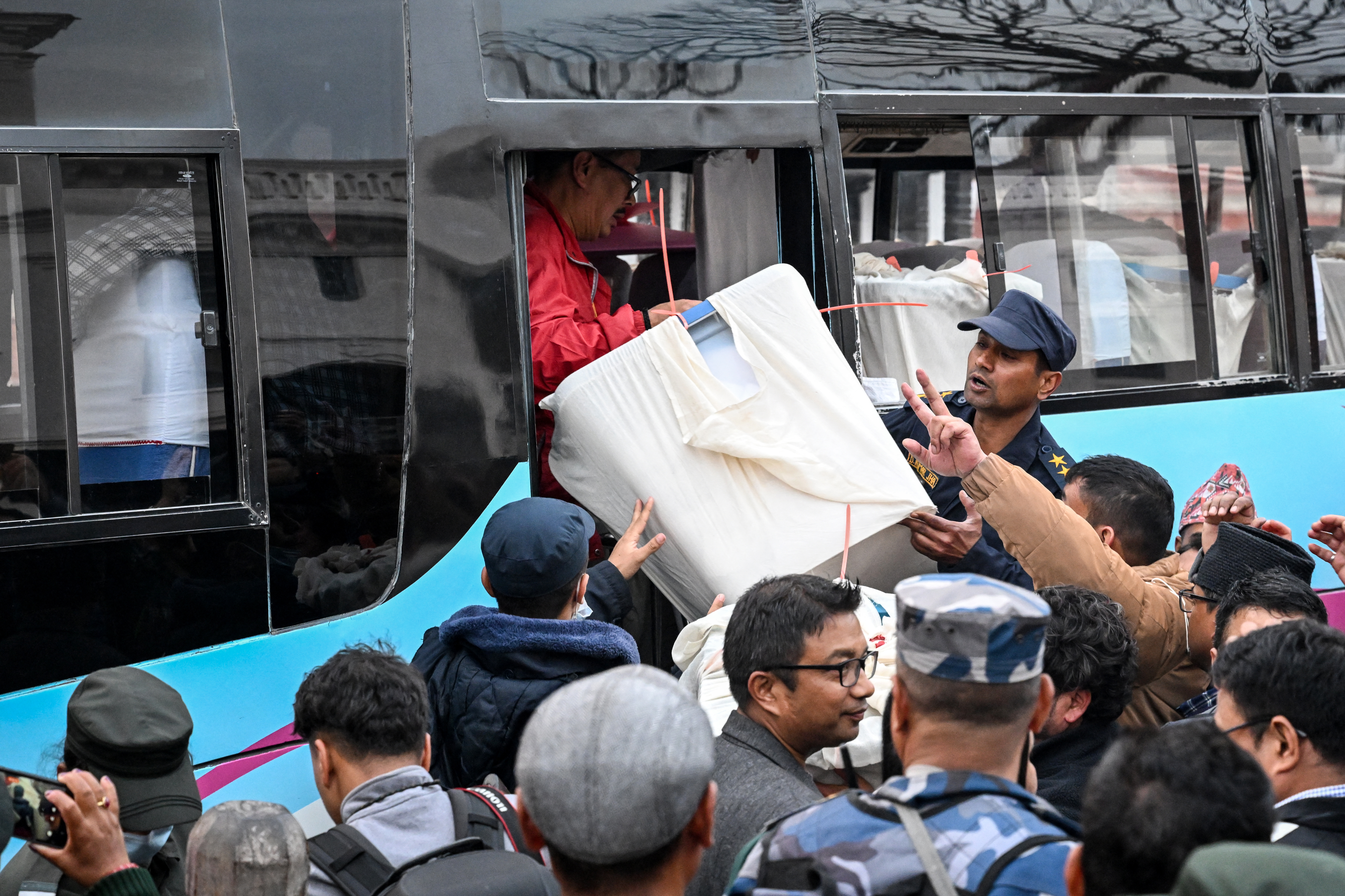 Security personnel and electoral officials carry ballot boxes to the counting centre after voting ends at a polling station during Nepal's general election in Kathmandu on March 5, 2026.