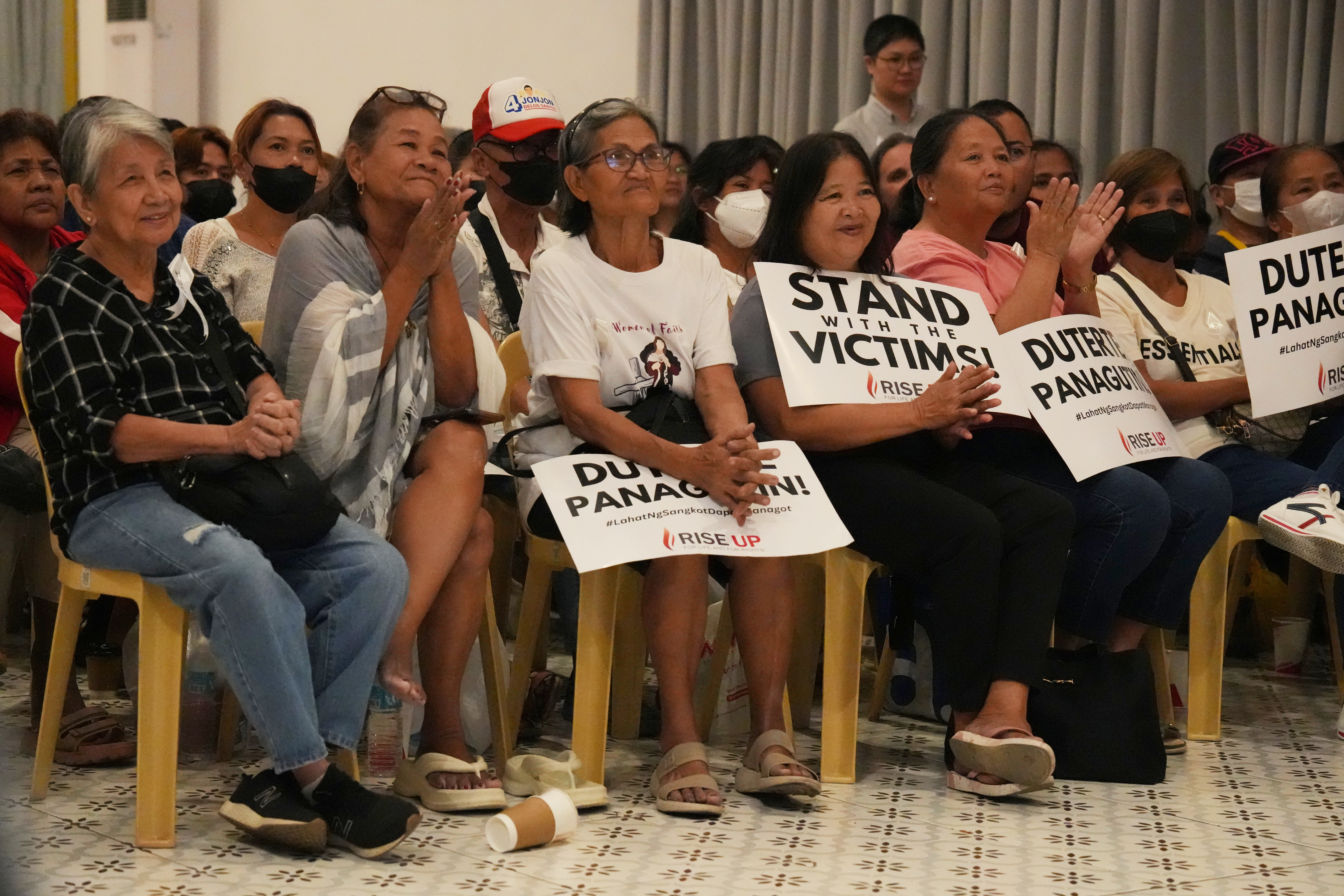 Families of victims on the deadly anti-drugs crackdowns of former Philippine President Rodrigo Duterte react as they watch a live stream of Duterte's pre-trial hearing from The Hague, at a venue in Quezon City, Philippines on Monday, Feb. 23, 2026.(AP Photo/Aaron Favila)