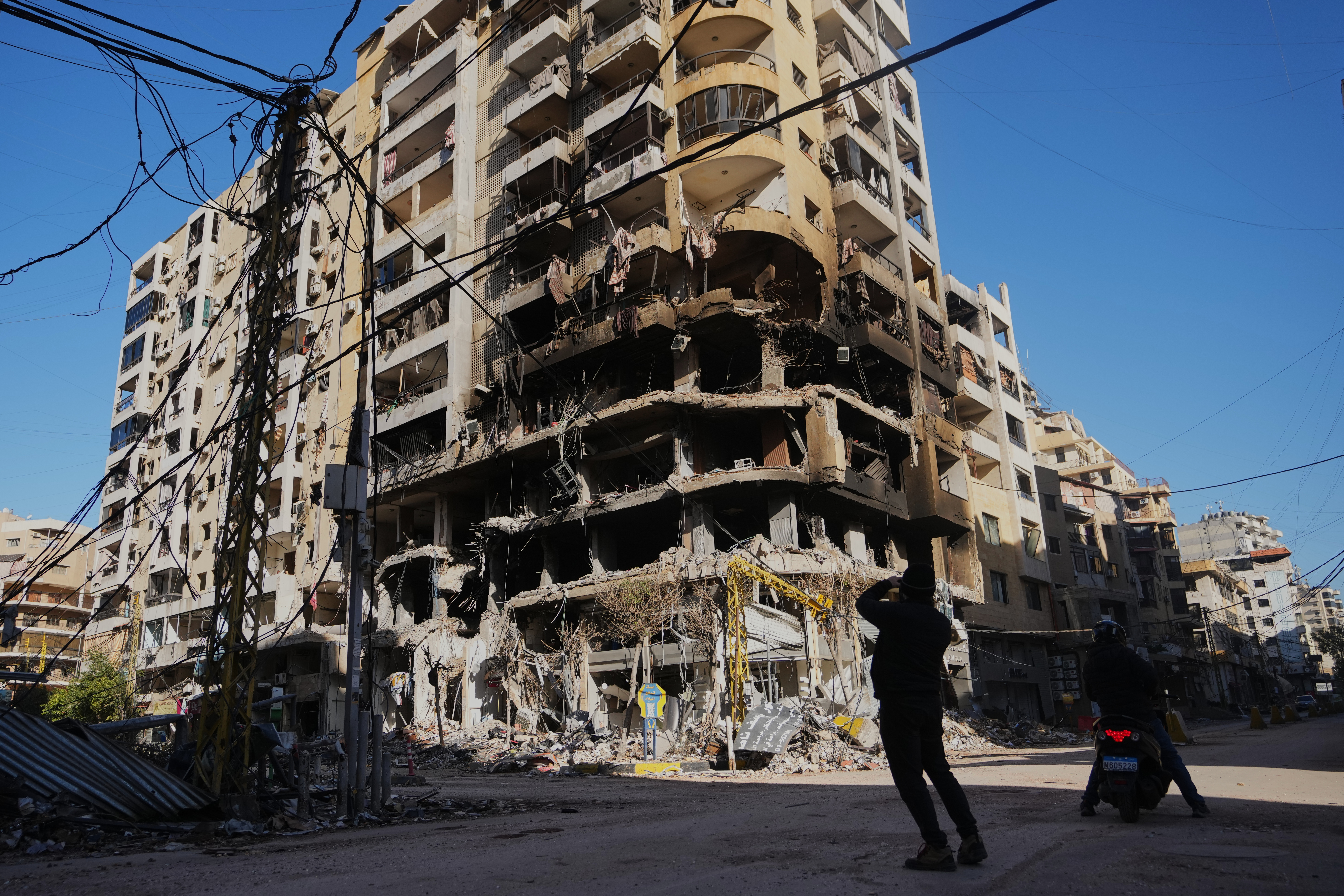 A man photographs a building damaged by an Israeli airstrike in Dahiyeh, Beirut's southern suburbs, Lebanon, Tuesday, March 17, 2026. (AP Photo/Hassan Ammar)