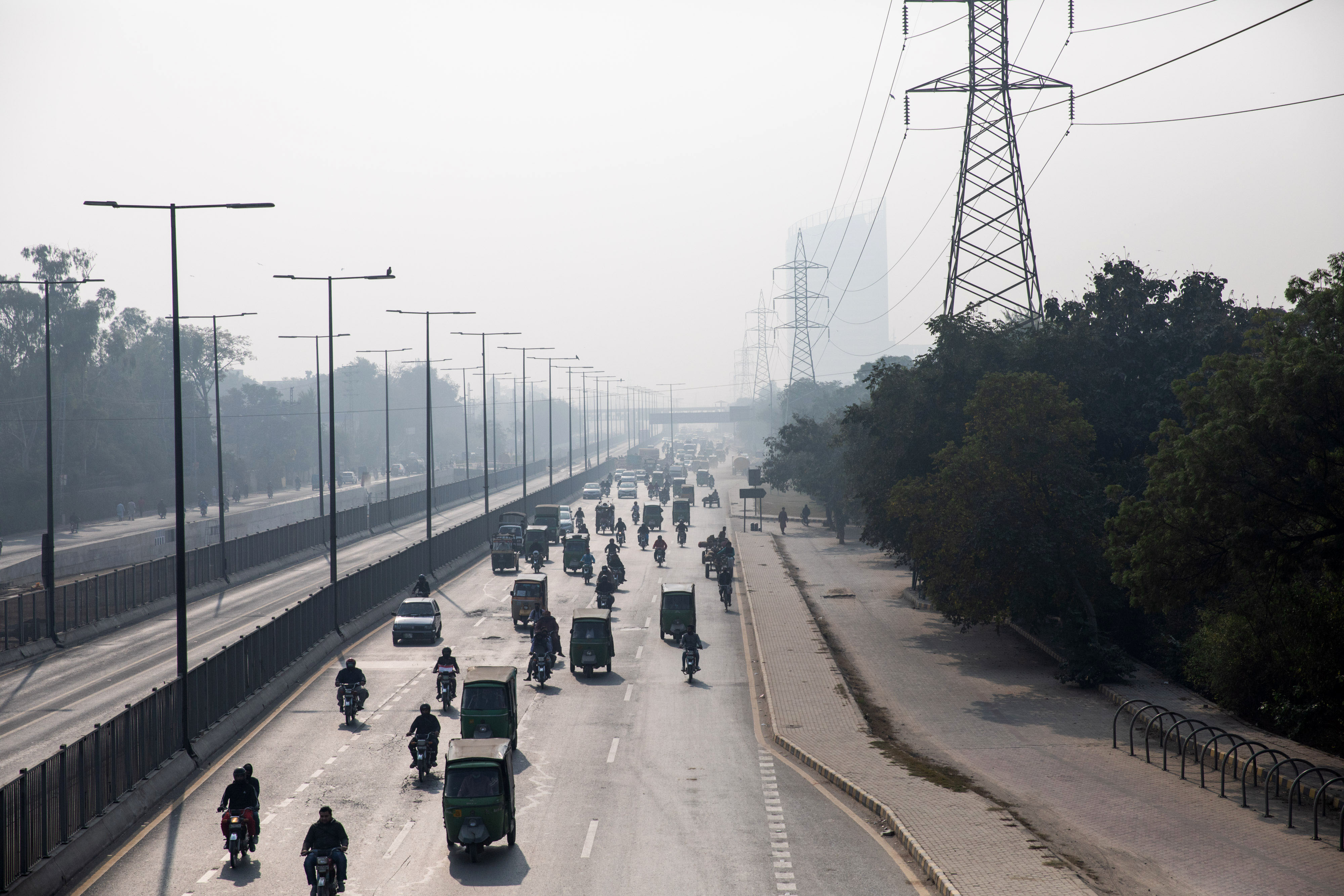 LAHORE, PAKISTAN - NOVEMBER 25: People drive through smog on November 25, 2021 in Lahore, Pakistan. Last week, Lahore was the world's most polluted city, according to data from Swiss air quality monitoring platform, IQAir. Lahore overtook Delhi for that top spot with an air quality ranking of 348 AQI, well above what's considered hazardous. Lahore, a city of 11 million people, frequently ranks among the worst in the world for air pollution, with current conditions brought on by crop burning, diesel fumes, and the onset of winter. (Photo by Betsy Joles/Getty Images)