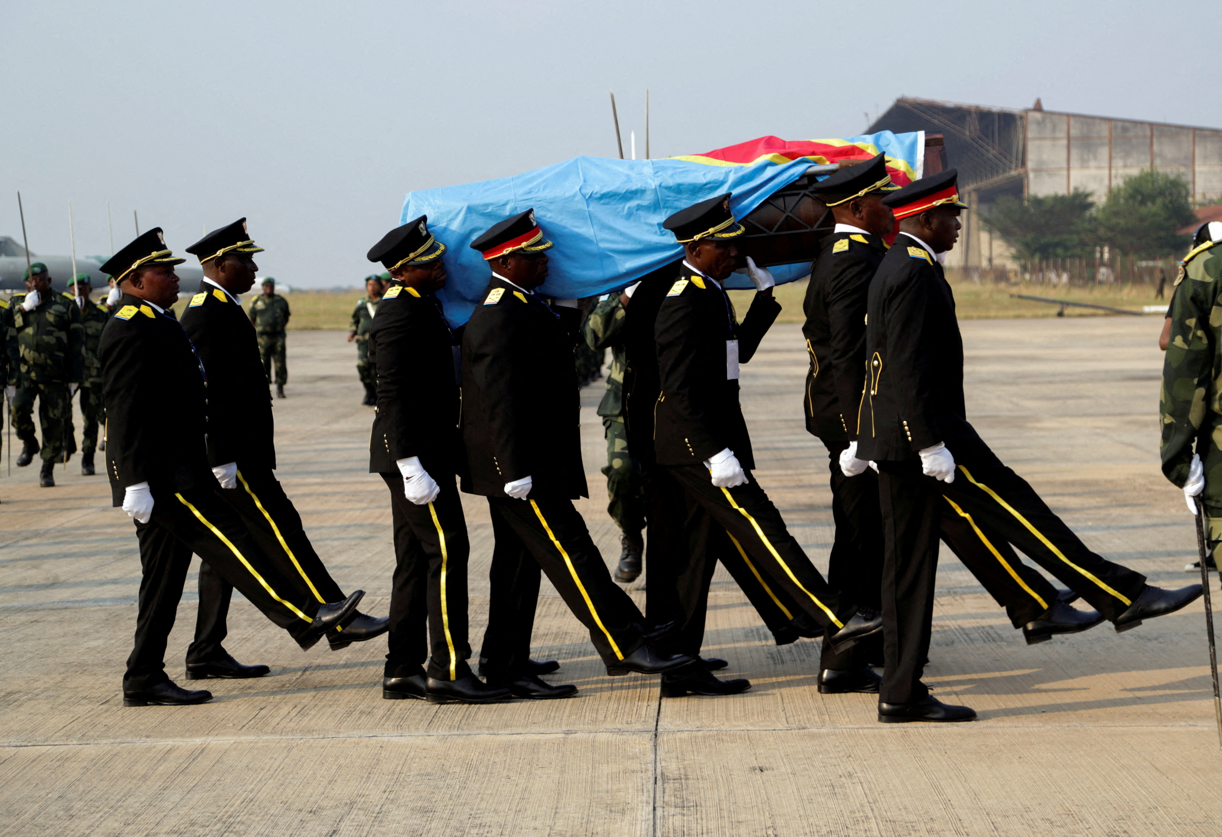 FILE PHOTO: Guards of honour members carry a coffin that contains the only known remains, a tooth of the murdered Congolese independence hero Patrice Lumumba, after he was returned to his family by the Belgian government at Airport in Kinshasa, Democratic Republic of Congo June 27, 2022. REUTERS/Justin Makangara/File Photo