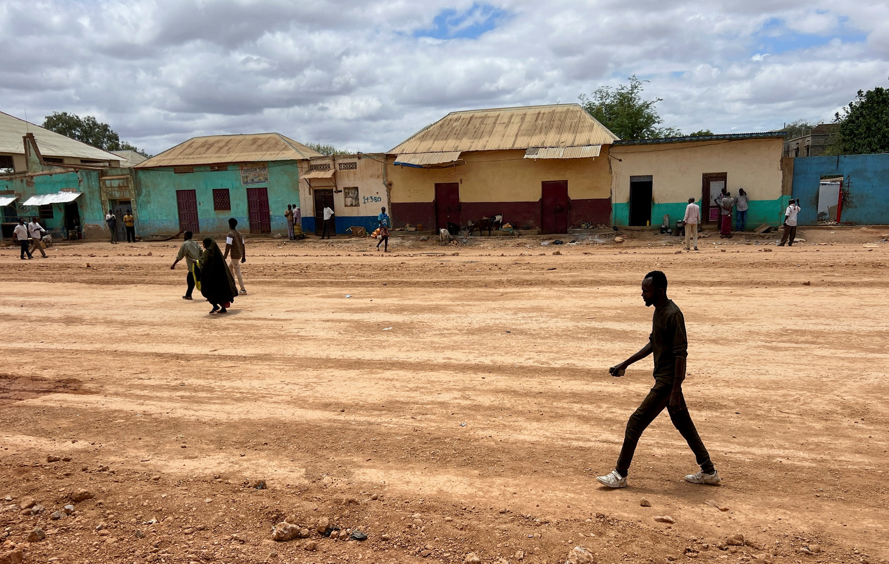 Civilians walk along a deserted street following clashes between Somalia's federal army and forces loyal to the South West state, home to international peacekeepers and humanitarian agencies, in an area affected by drought, conflict and displacement, in Baidoa