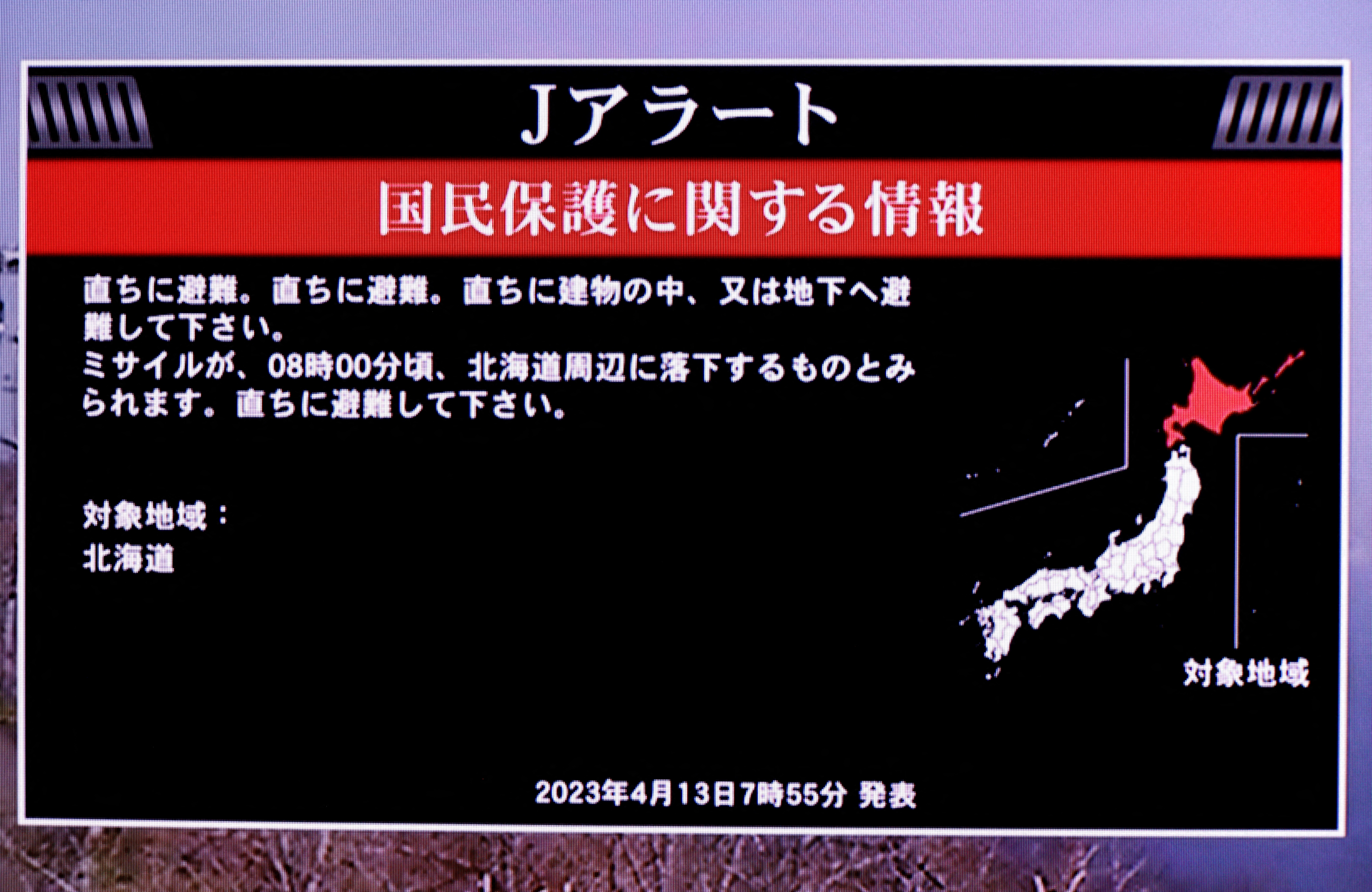 A TV screen displays a warning message called "J-alert" after the Japanese government issued an alert, following a ballistic missile launch by North Korea, in this photo taken in Tokyo, Japan April 13, 2023. The message reads: Japanese government warns citizens of the northernmost main island of Hokkaido to take immediate cover and stay inside buildings, saying a missile was likely to fall near the island. REUTERS/Issei Kato