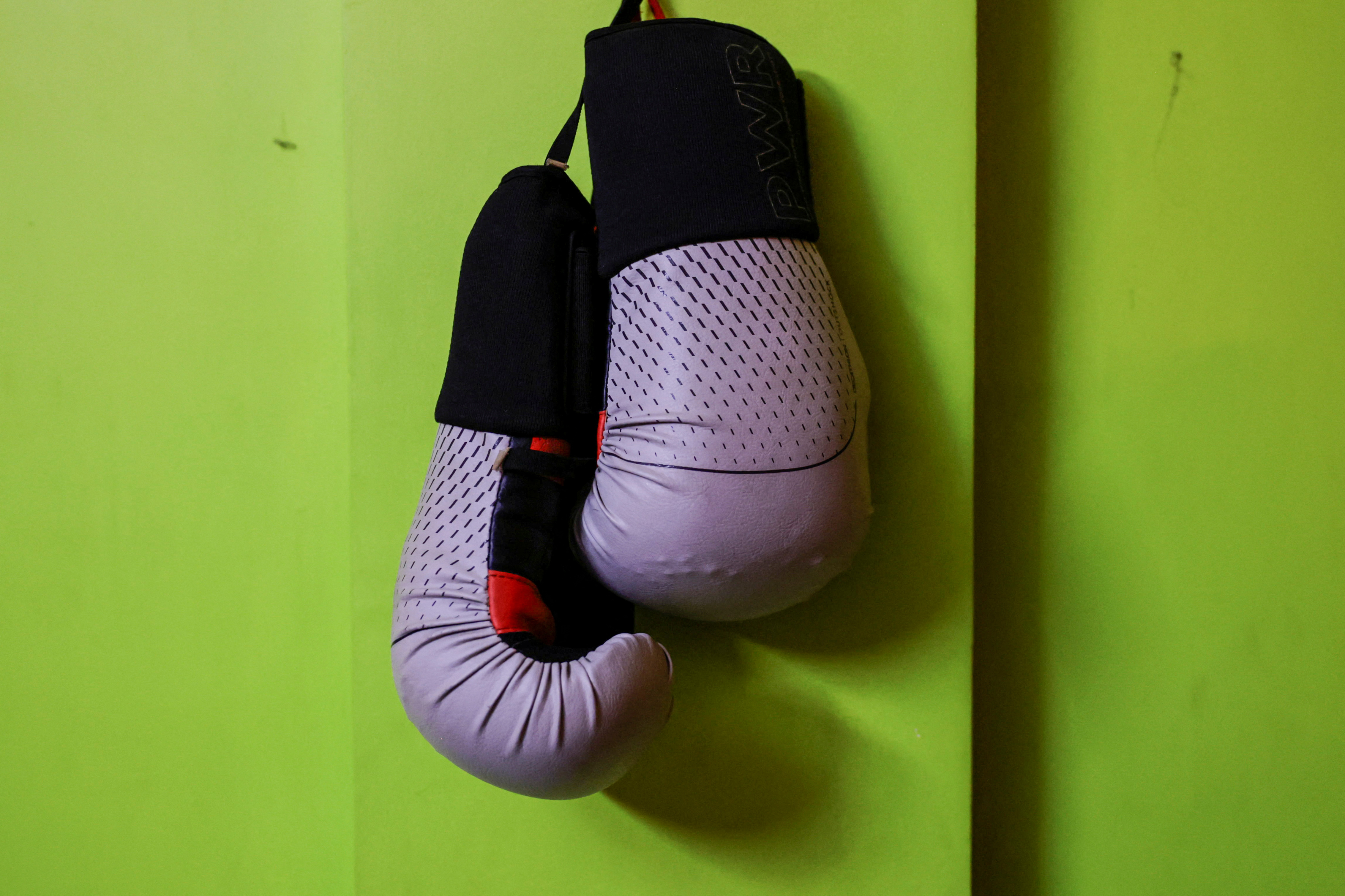 A pair of boxing gloves that belonged to Shreeyam Chaulagain, who died after sustaining a gunshot injury to his head during anti-corruption protests that toppled the government, hangs on the wall of a rented apartment where his parents live, in Kathmandu, Nepal October 1, 2025. REUTERS/Navesh Chitrakar