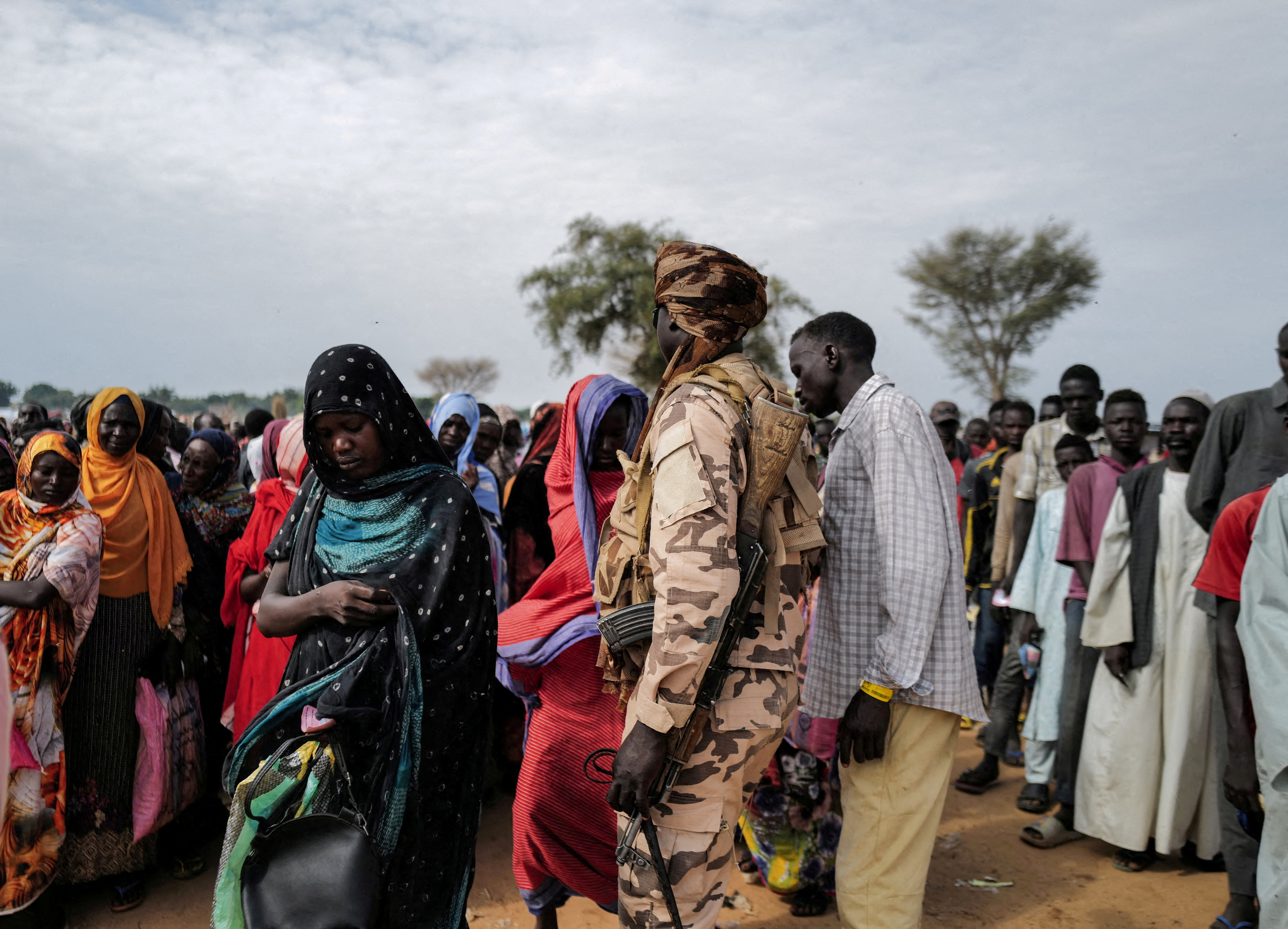 Sudanese refugees, who have fled the violence in their country, line up to receive food rations from World Food Programme in Adre, Chad