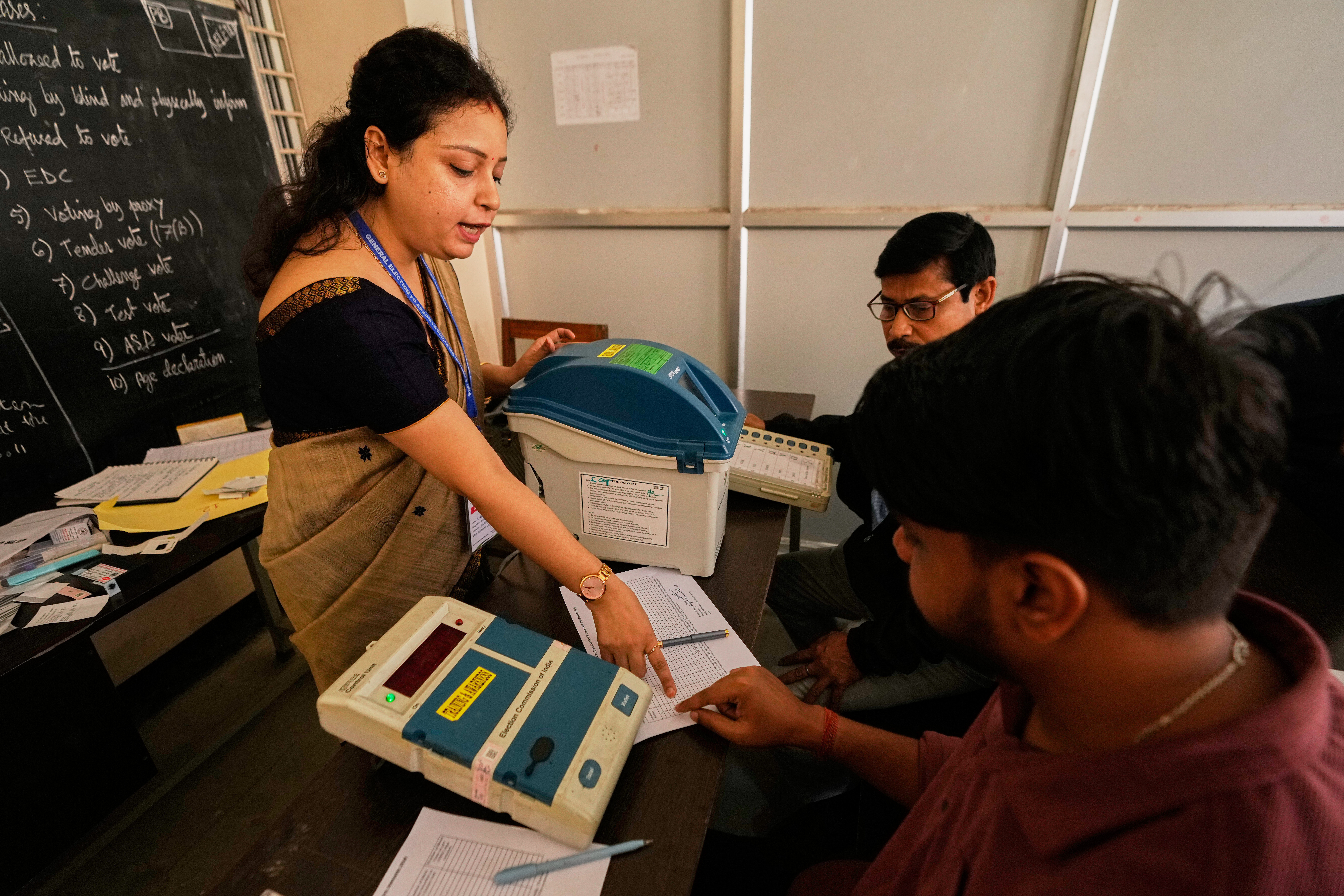 A polling official demonstrates how to use electronic voting machines.