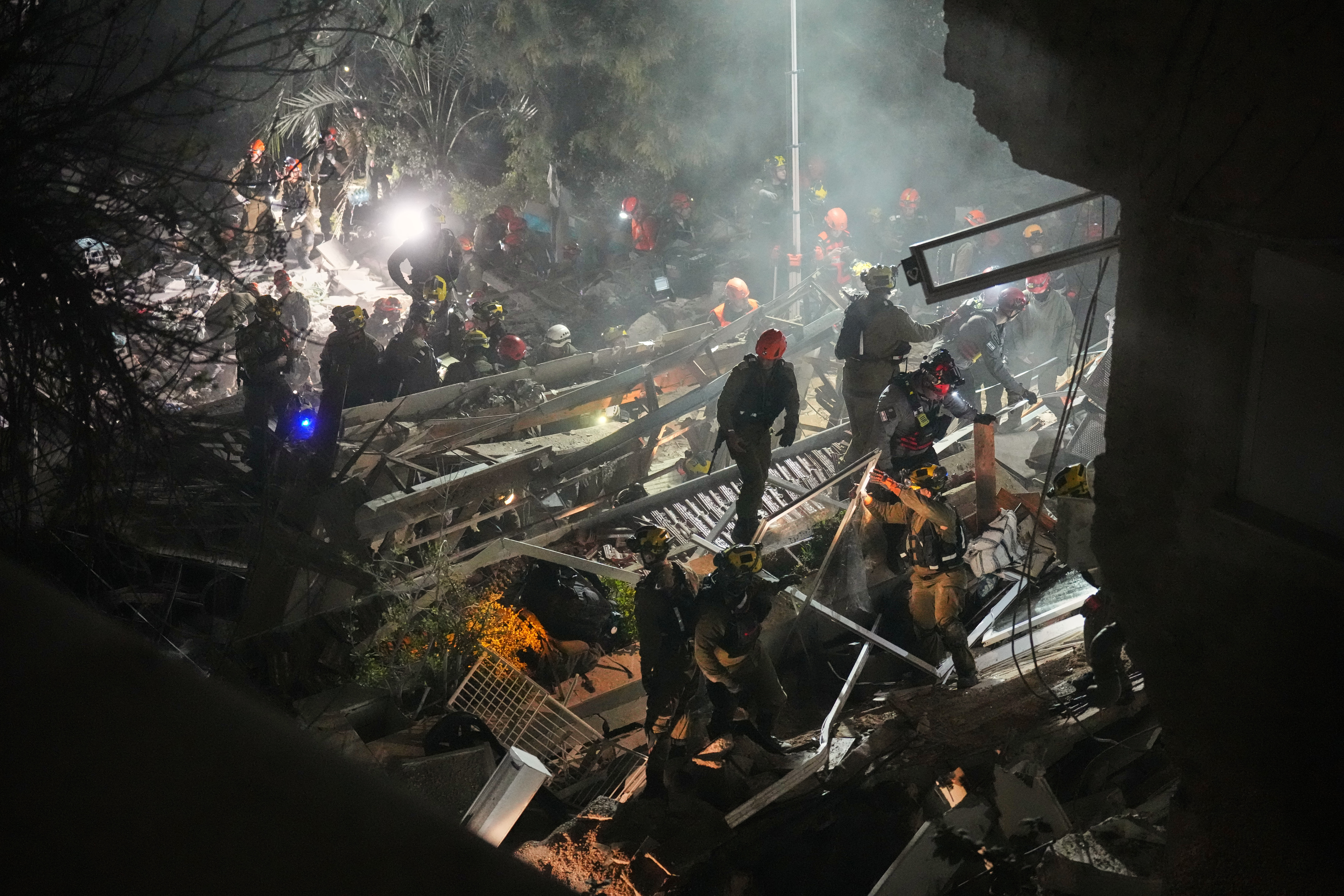 Israeli security forces and rescue teams work amid the rubble of a residential building struck by an Iranian missile in Haifa, Israel, Sunday, April 5, 2026.