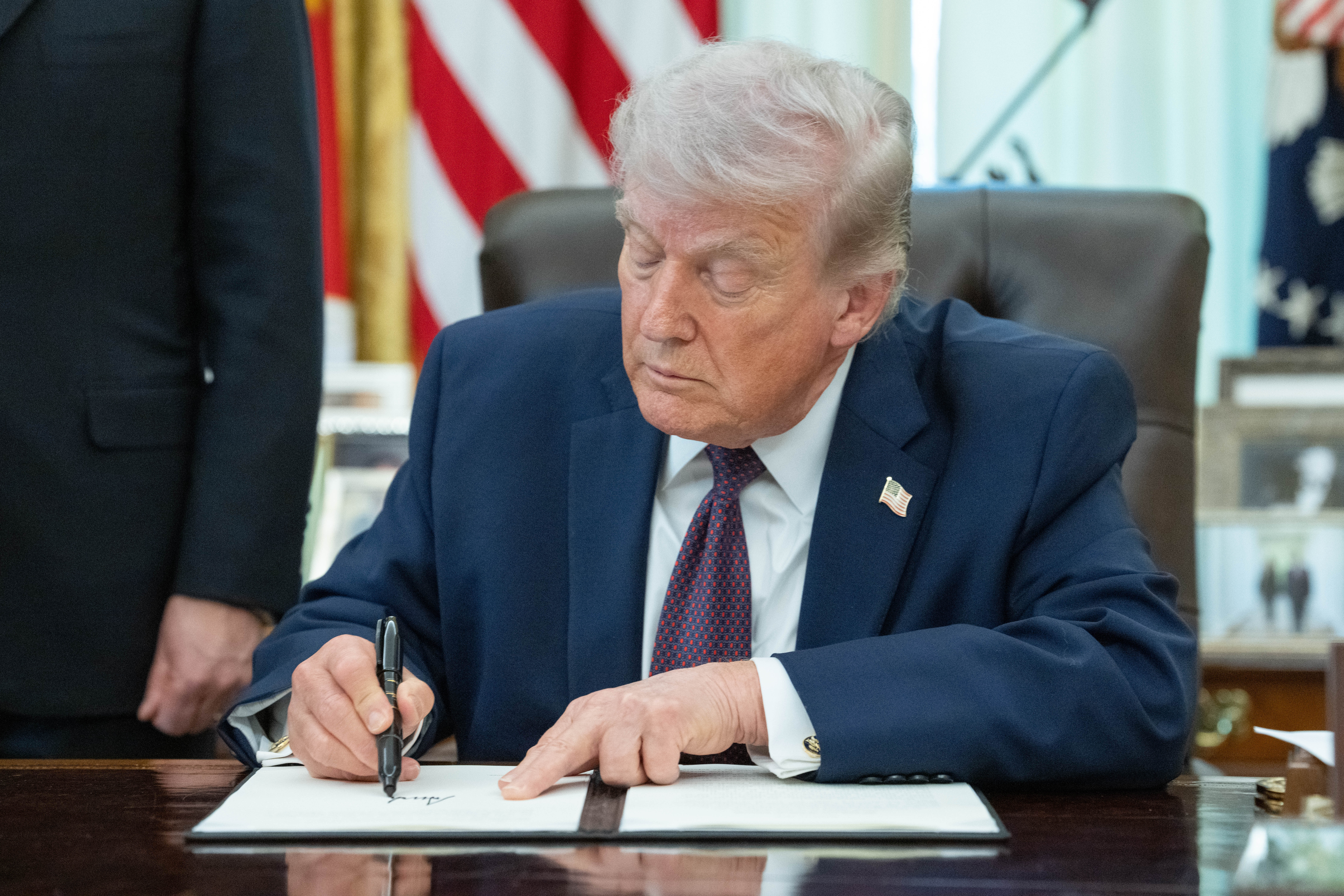 epa12863108 US President Donald J Trump signs an executive order in the Oval Office of the White House in Washington, DC, USA, 31 March 2026. The order directs the federal government, through the US Postal Service, to provide states with voter eligibility data. EPA/AARON SCHWARTZ / POOL